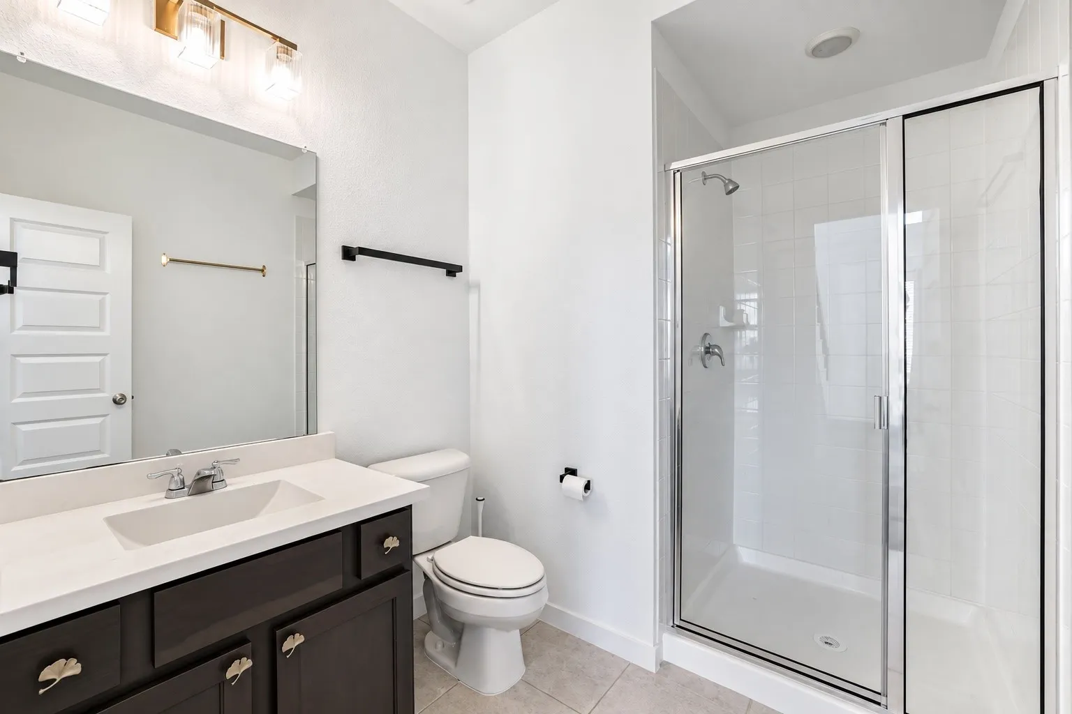 Modern vanity with white countertop and integrated sink, chrome faucet, and decorative hardware