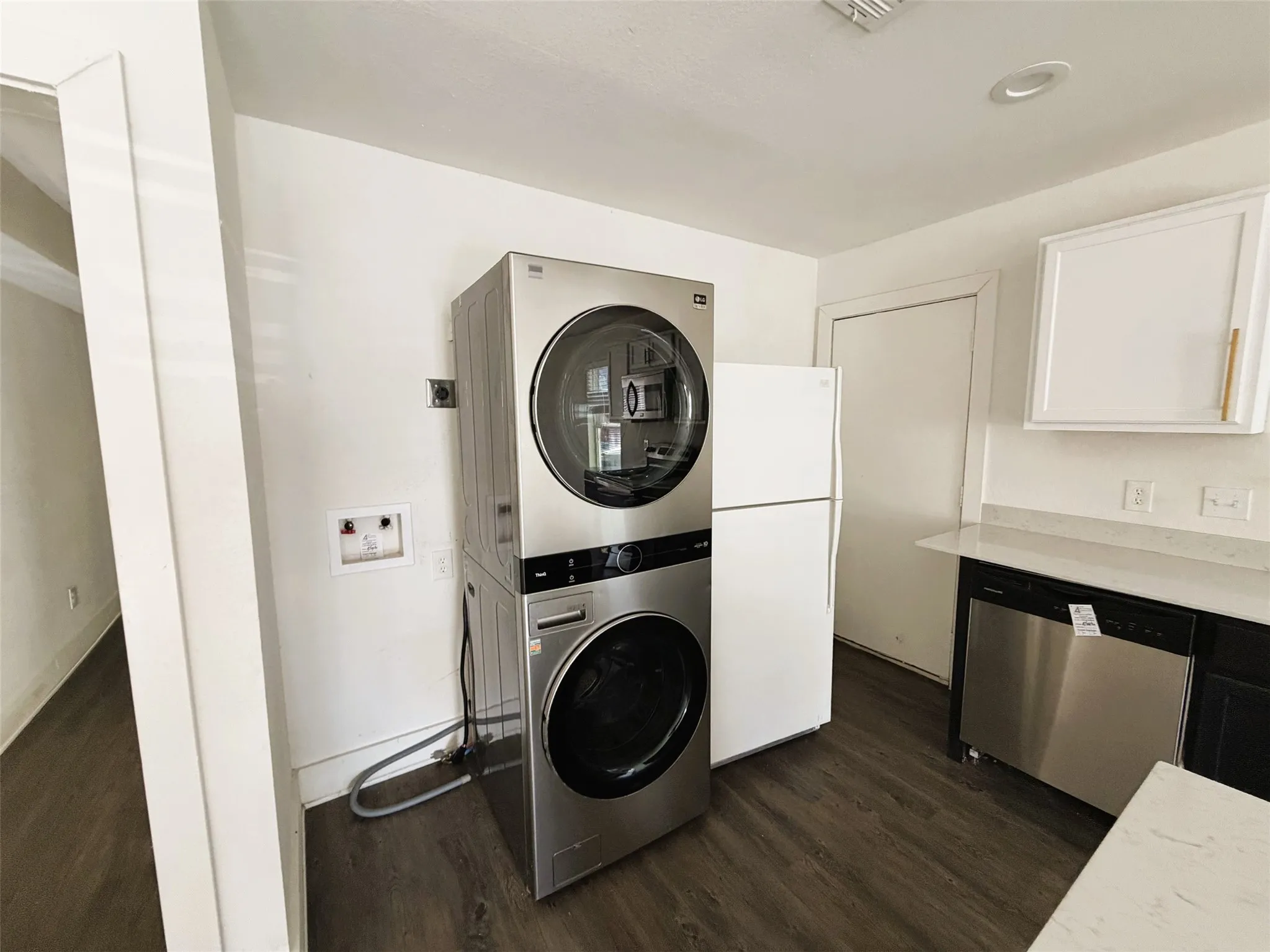 Laundry in kitchen with stackable and fridge