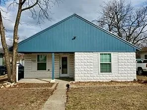 Gable roofline with blue vertical siding, textured white exterior, front entry door, and a concrete pathway