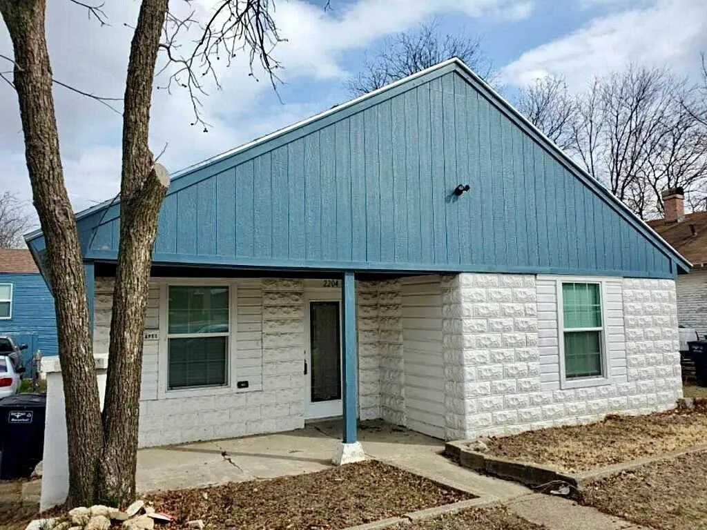 Gable roofline with blue vertical siding