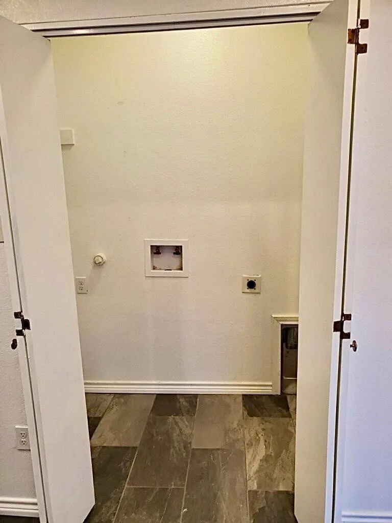 Utility closet with tile flooring, bifold doors, and laundry hookups