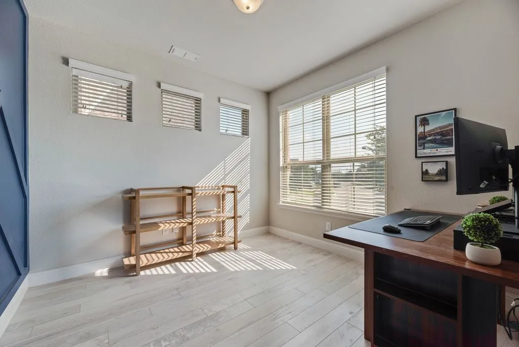 Light wood-finish flooring with a large picture window and three transom windows