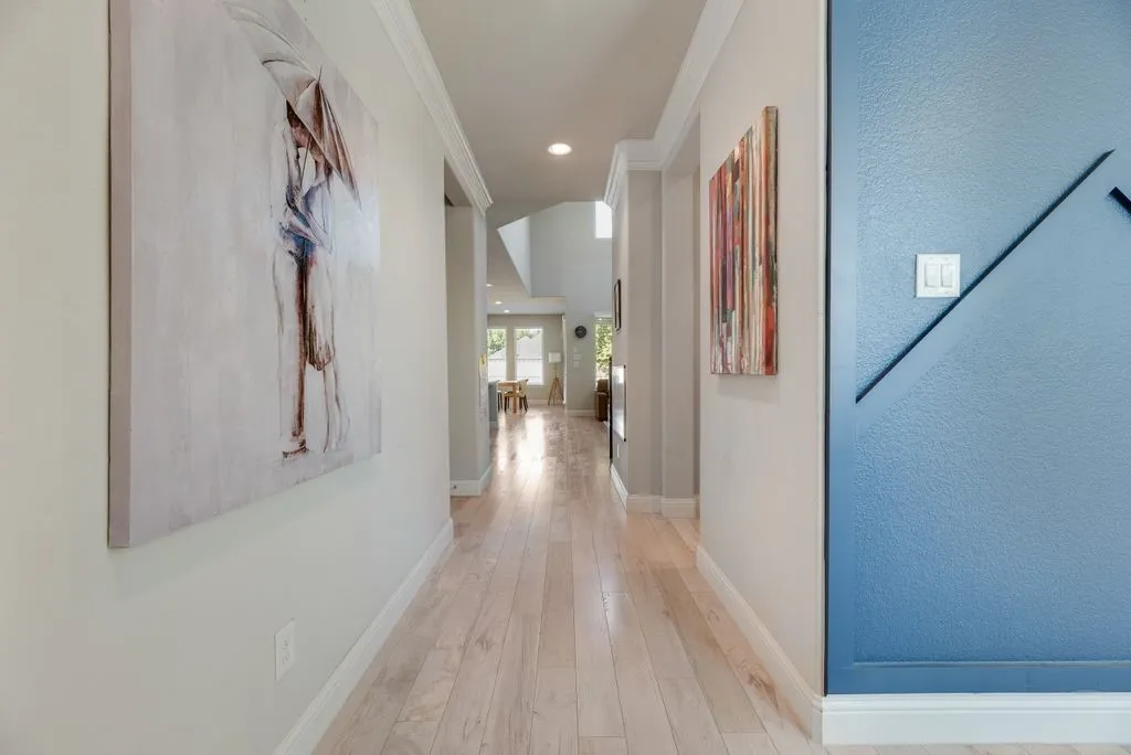 Extended hallway with wood-finish flooring, recessed lighting, and crown molding