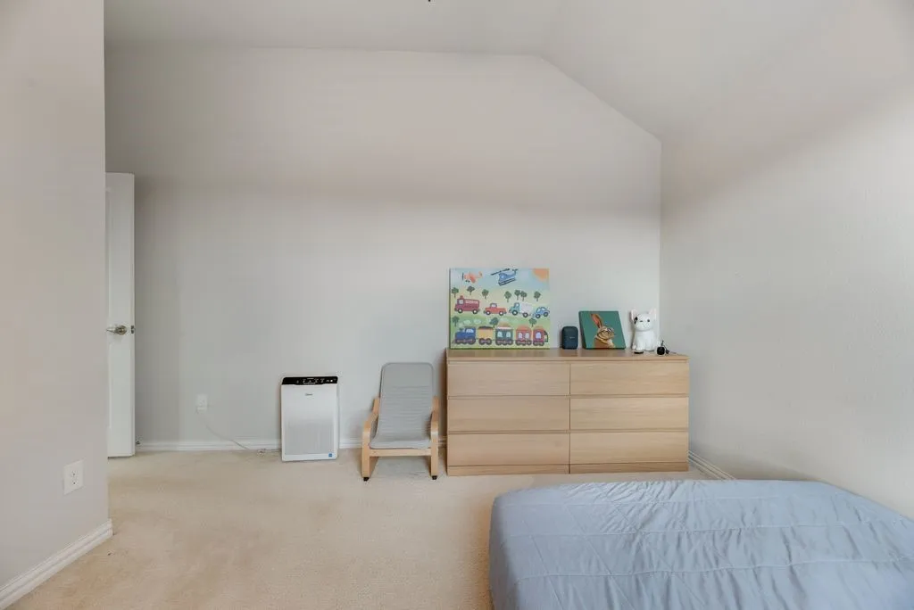 Vaulted ceiling, neutral wall color, carpeted flooring, white trim, white interior door