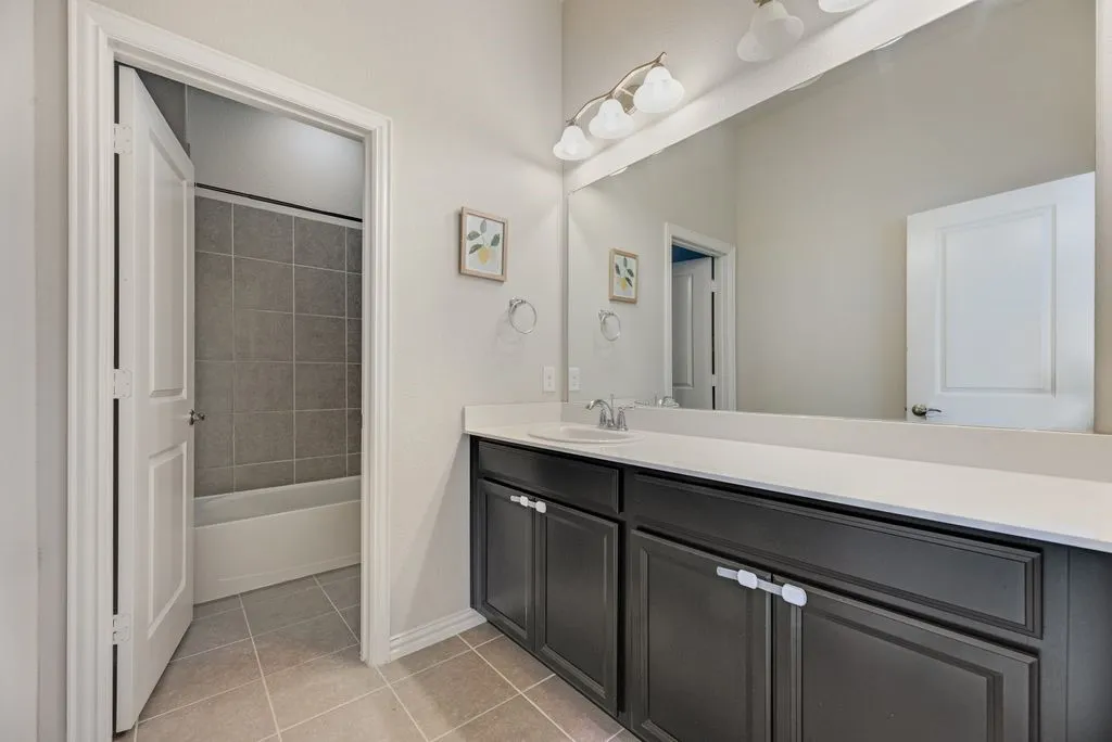 Vanity with dark cabinetry and white countertop