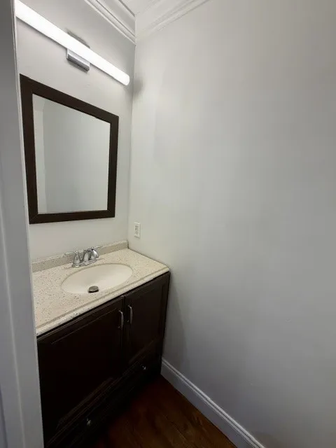 Dark wood-finish vanity with an integrated sink and light-colored countertop
