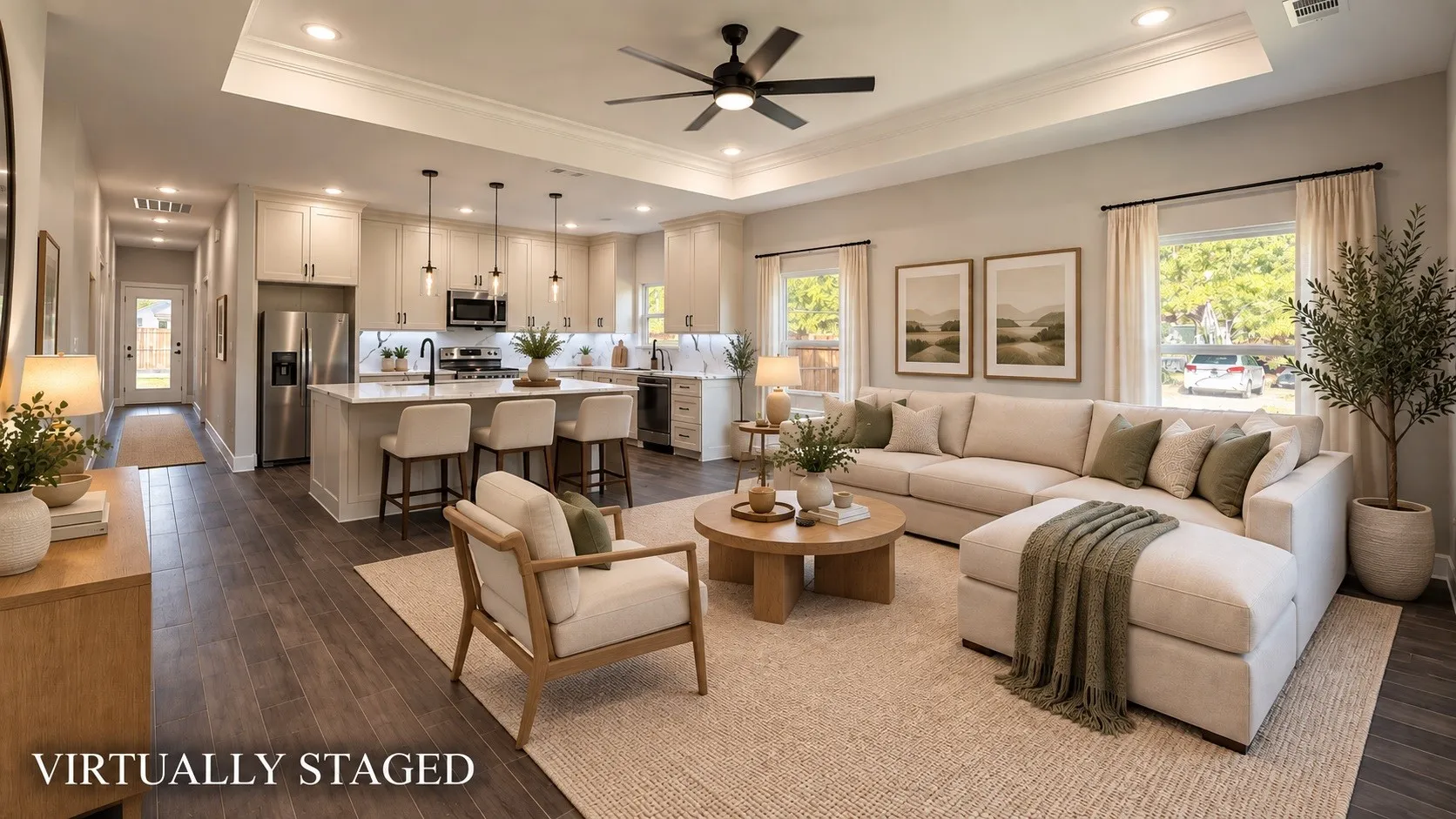Open-concept living space featuring wood-finish flooring, a tray ceiling with recessed lighting, and a kitchen island with pendant lighting