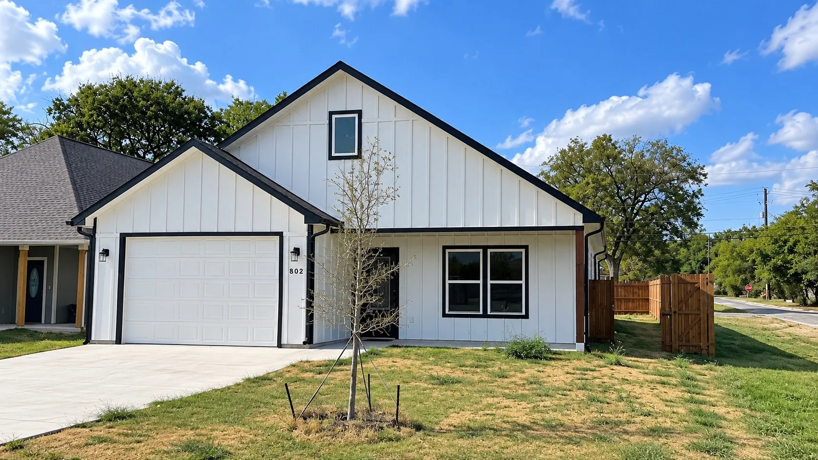 Modern farmhouse exterior with white vertical siding and black trim accents