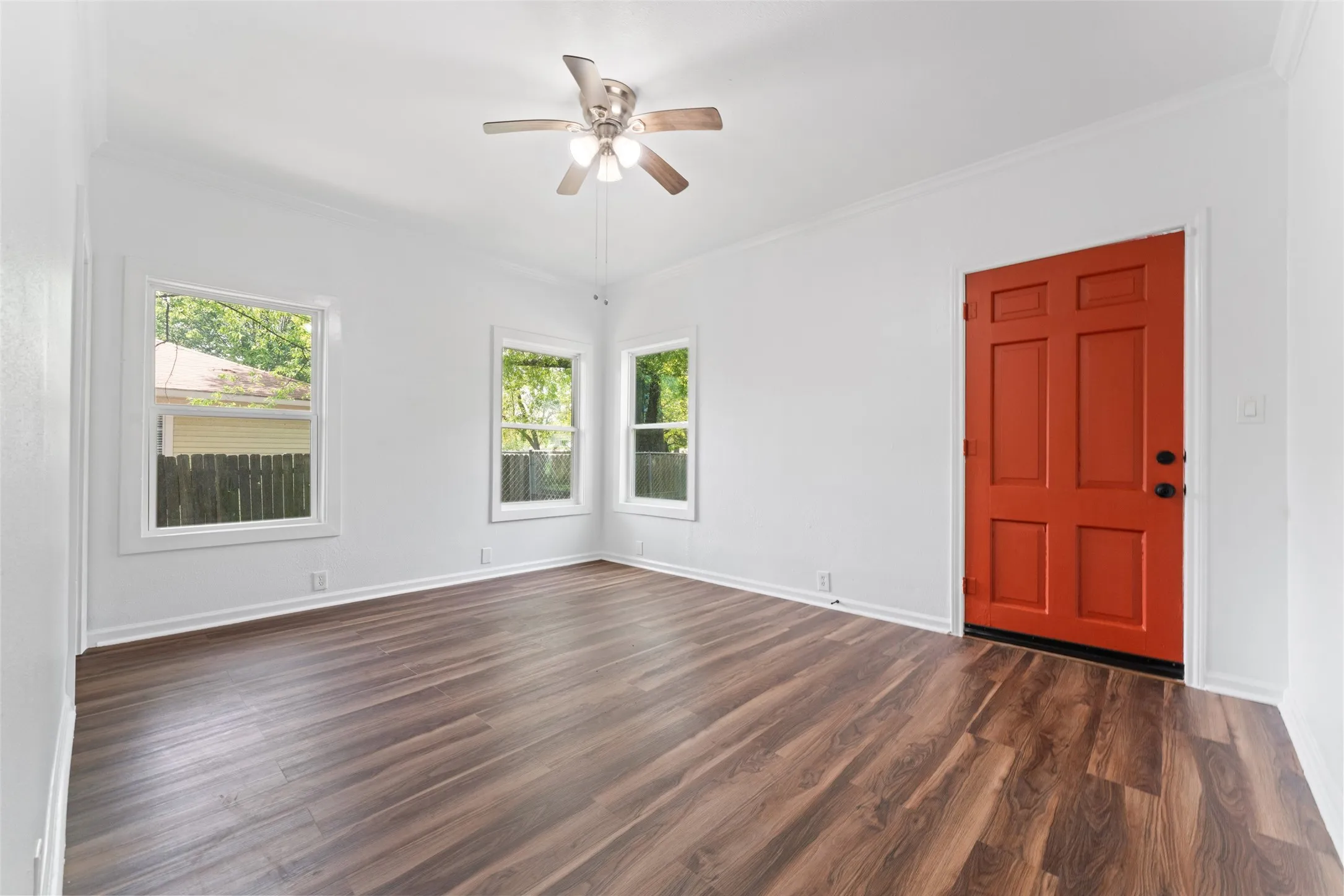 Wood-finish flooring, white walls, and a ceiling fan with integrated lighting