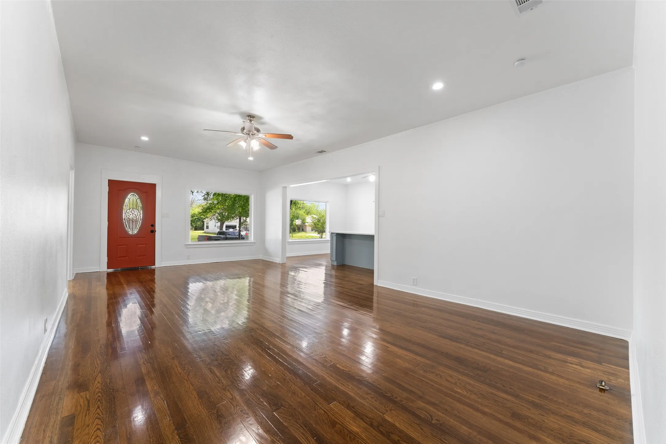 Polished wood-finish flooring, recessed lighting, and a ceiling fan with light fixture