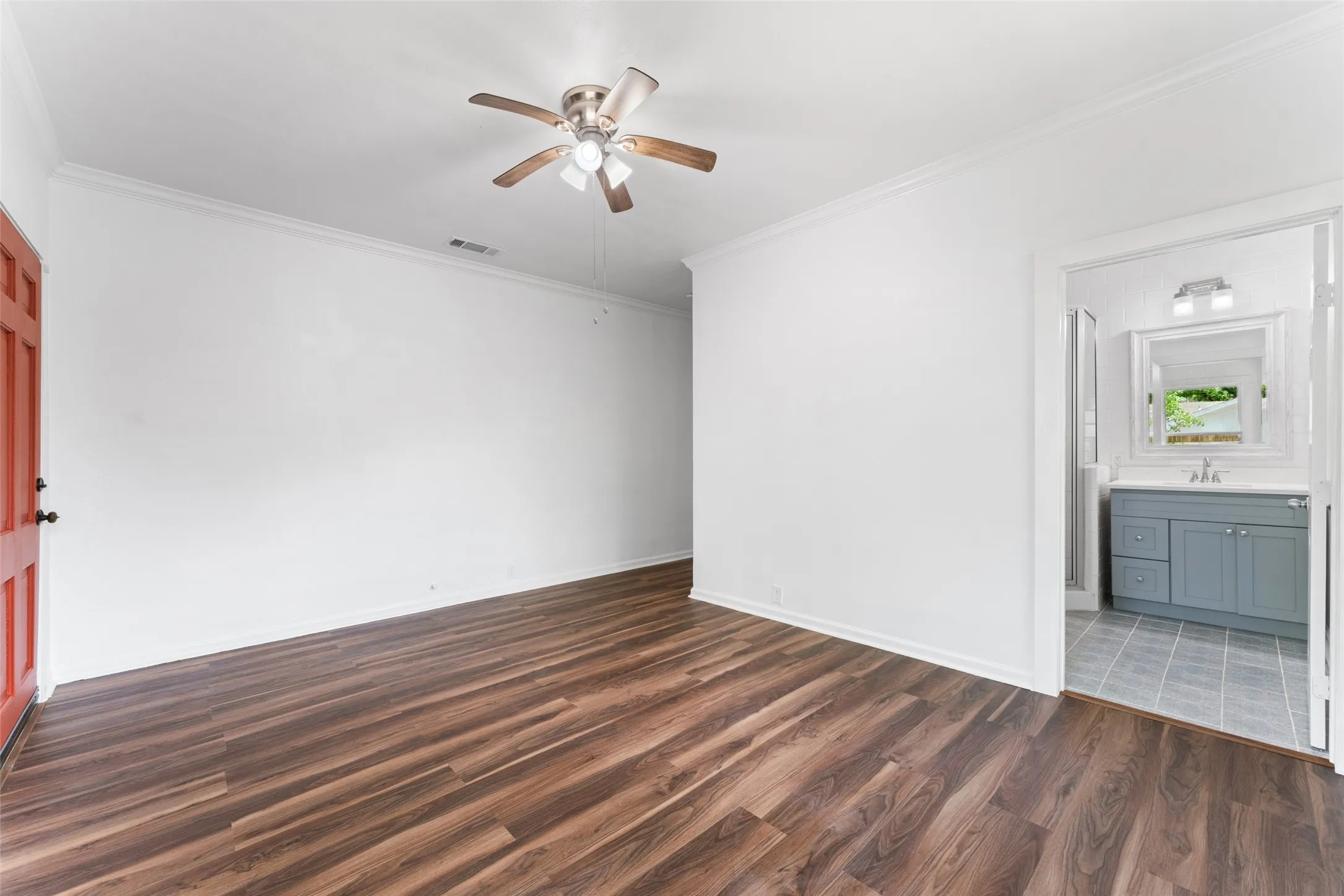 Wood-finish flooring throughout, white walls, and crown molding