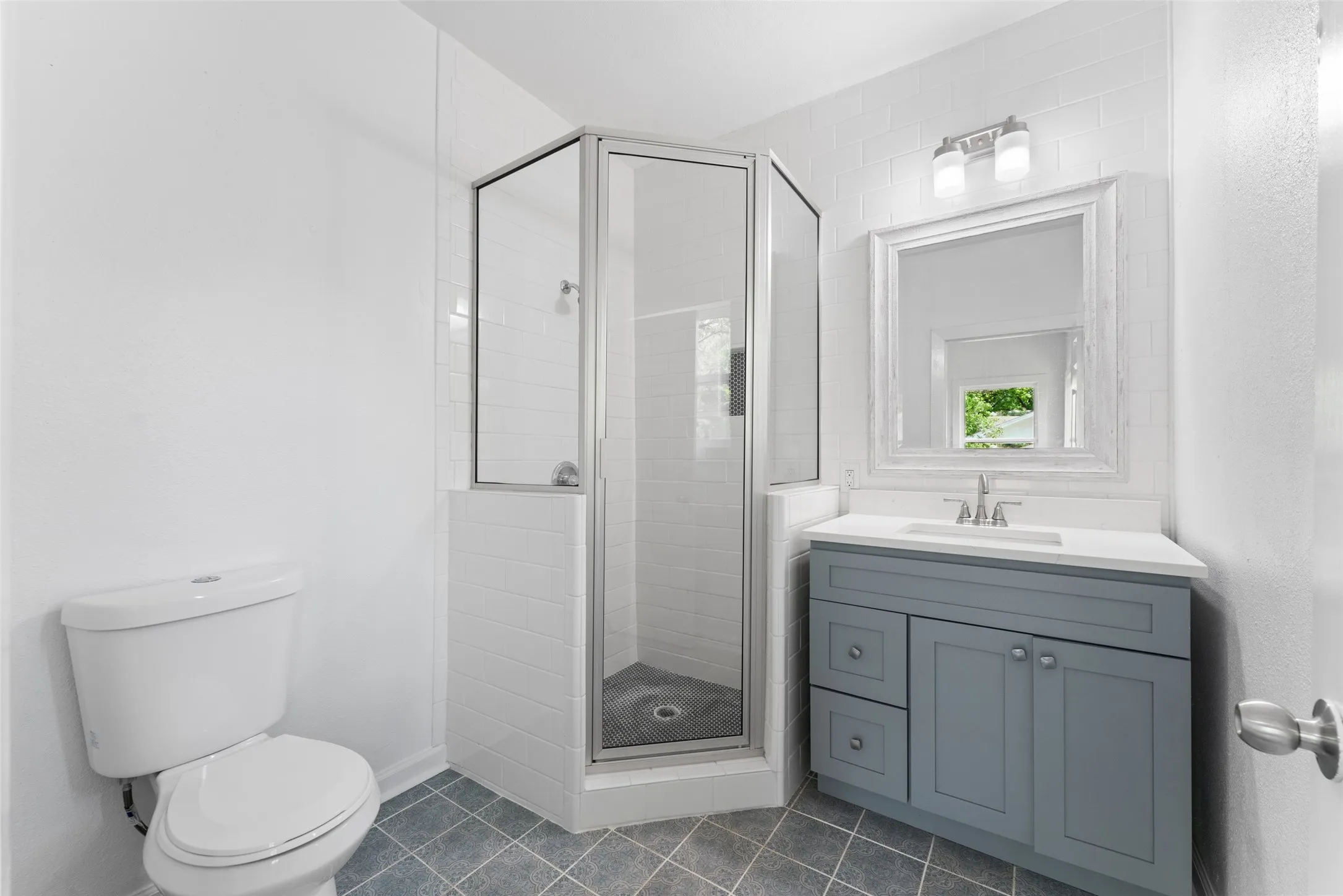 Corner glass-enclosed shower with subway tile surround