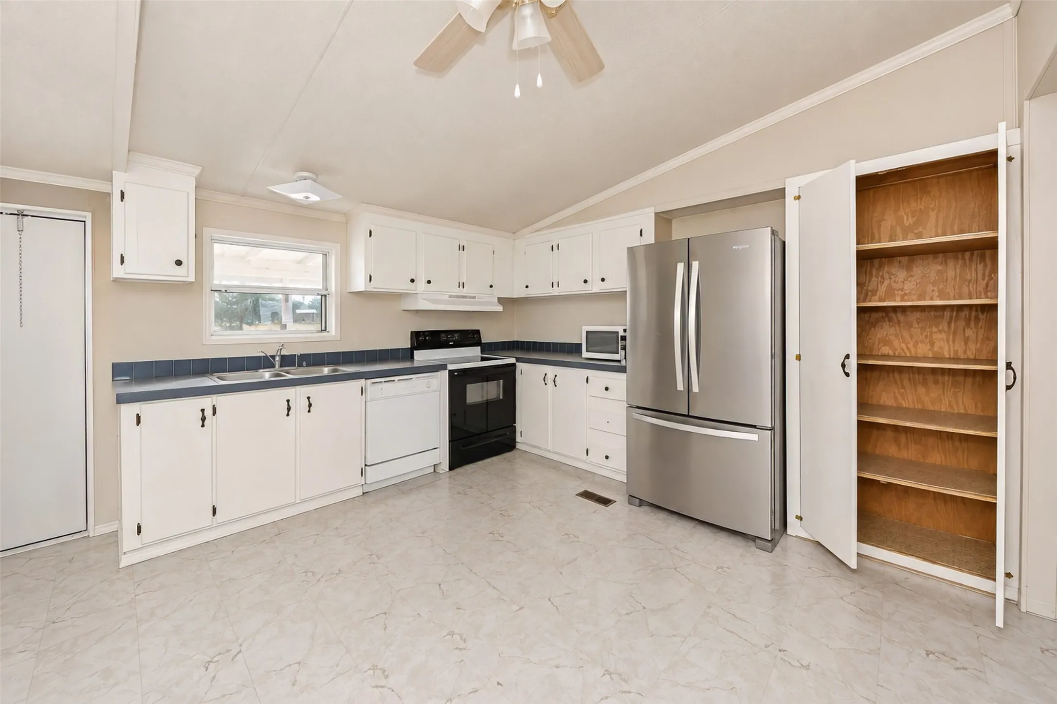 Kitchen featuring white cabinetry, a stainless steel refrigerator, an electric range, a dishwasher, and a built-in pantry with shelving