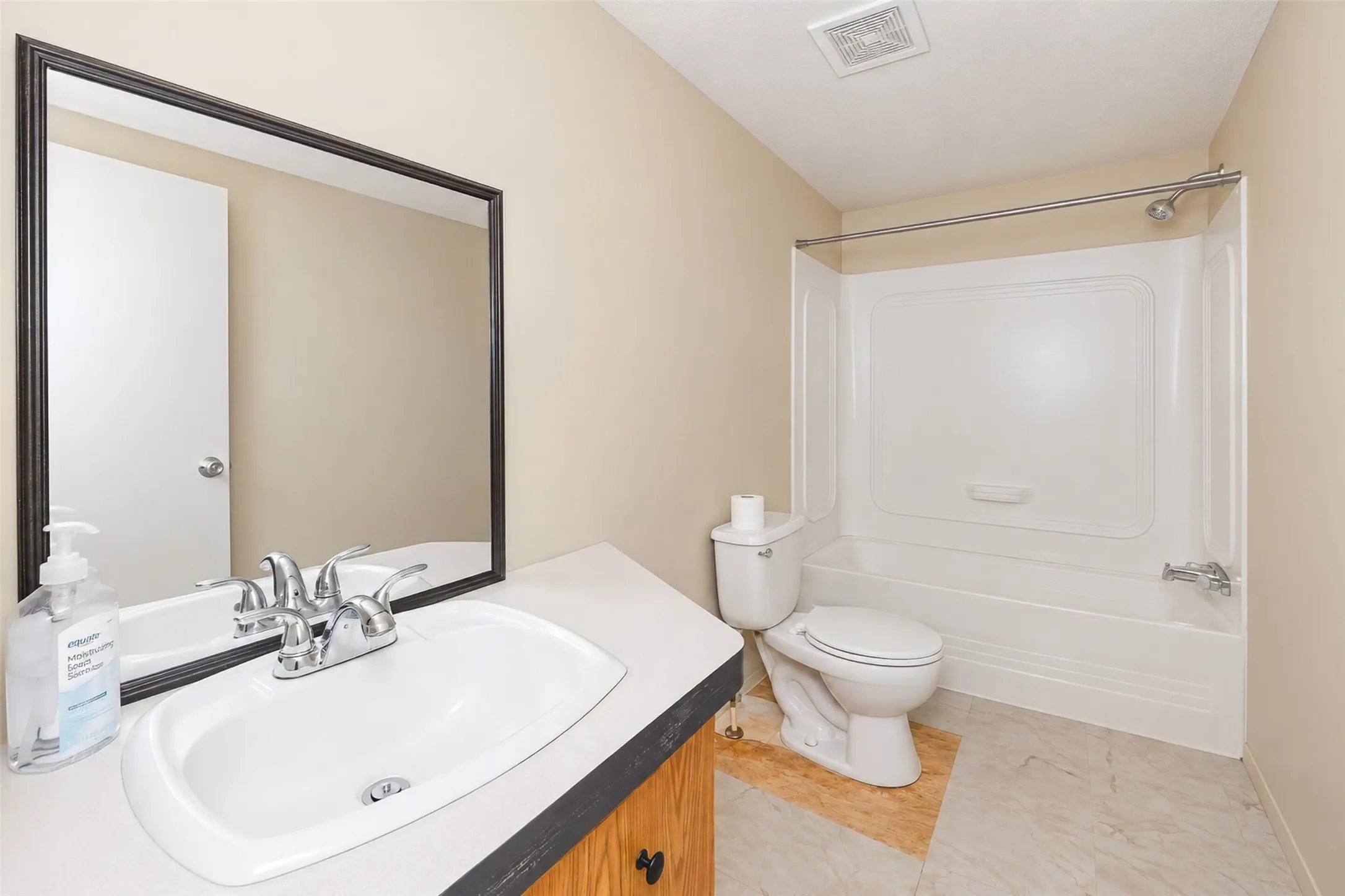 White acrylic tub and shower combination with chrome fixtures