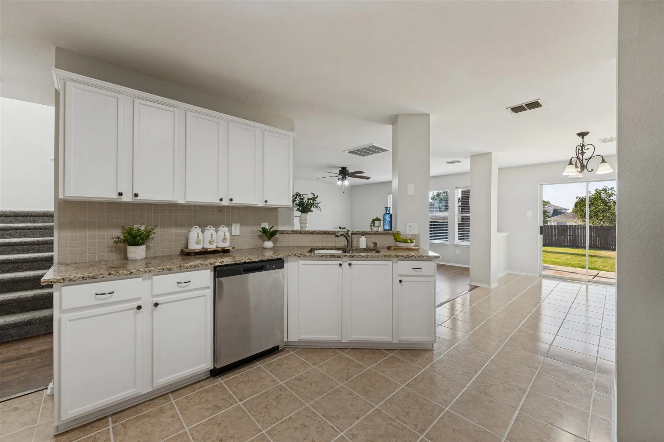 Kitchen featuring white cabinetry, a stainless steel dishwasher, and stone countertops