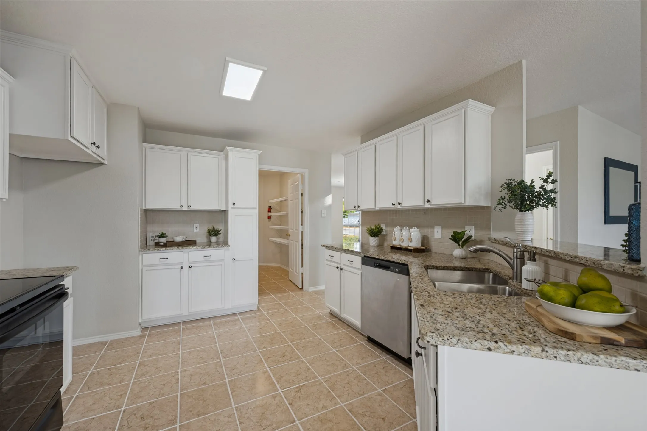 Kitchen featuring white cabinetry, tile flooring, granite countertops, and stainless steel appliances
