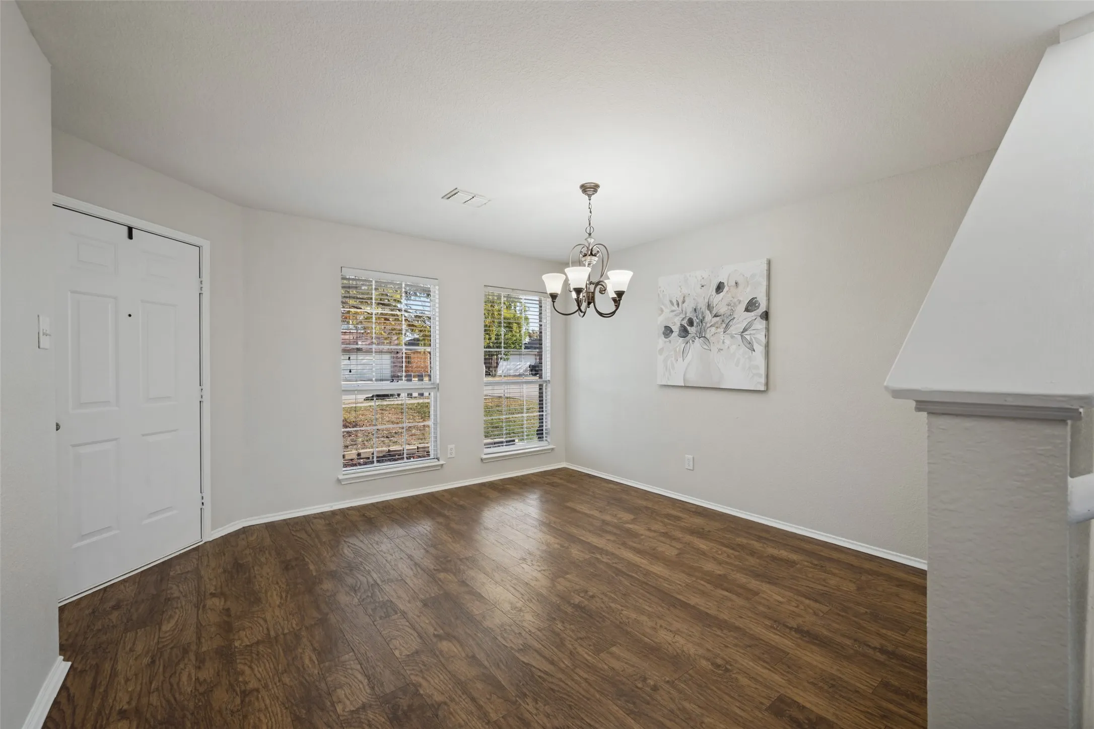 Wood-finish flooring with white baseboards throughout