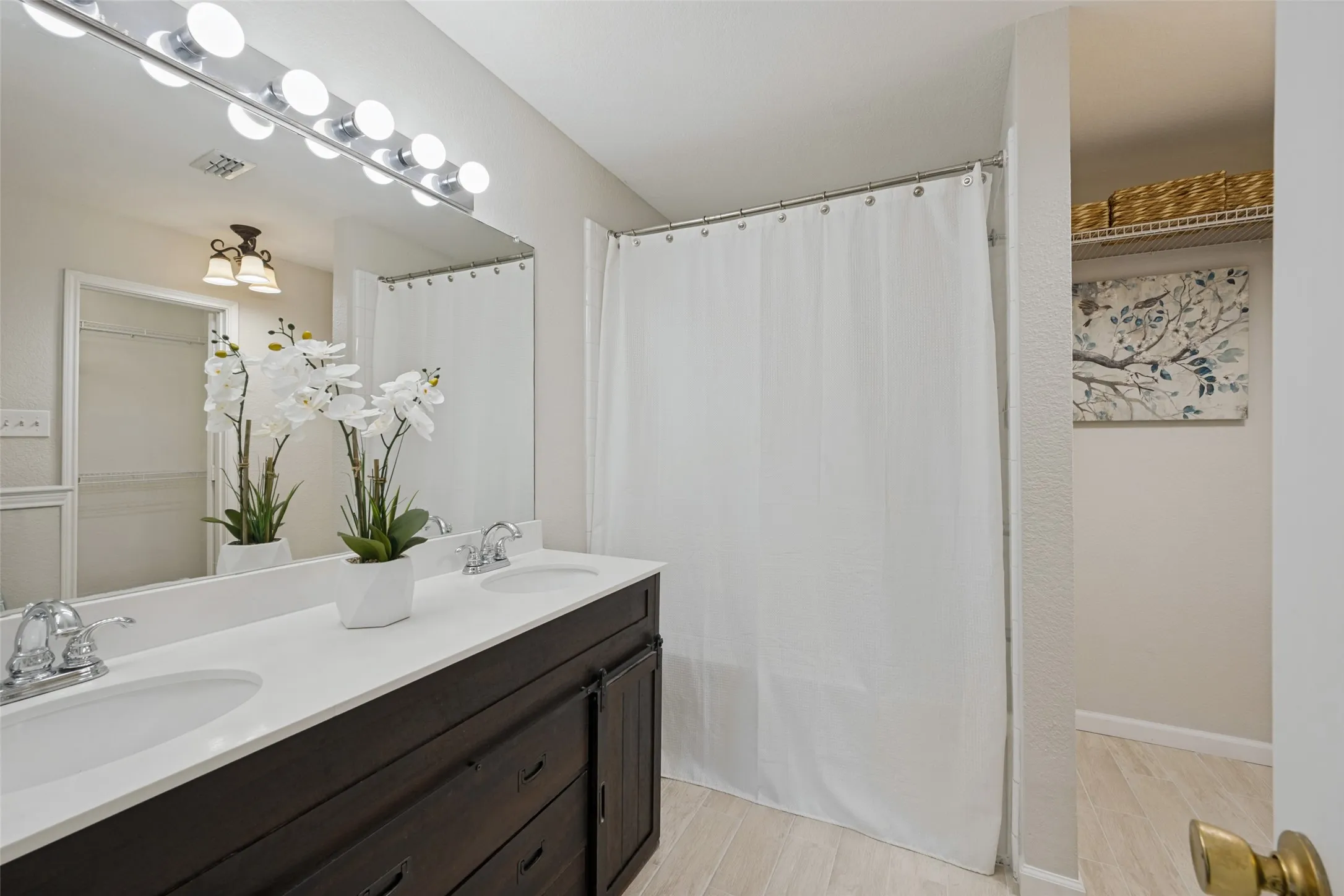 Dual vanity with white countertops, dark wood-finish cabinetry, and chrome fixtures