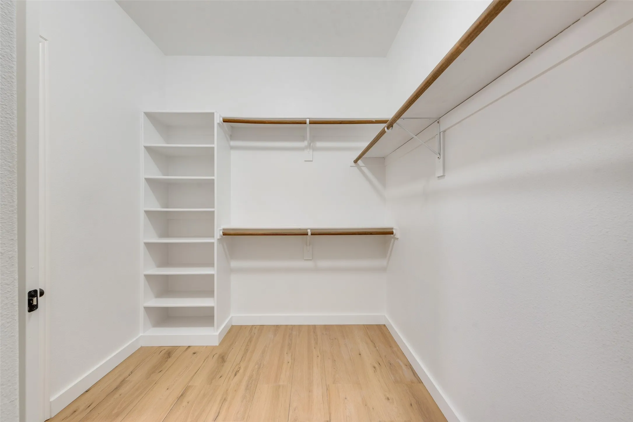 Primary closet with extra rods, built in shelves