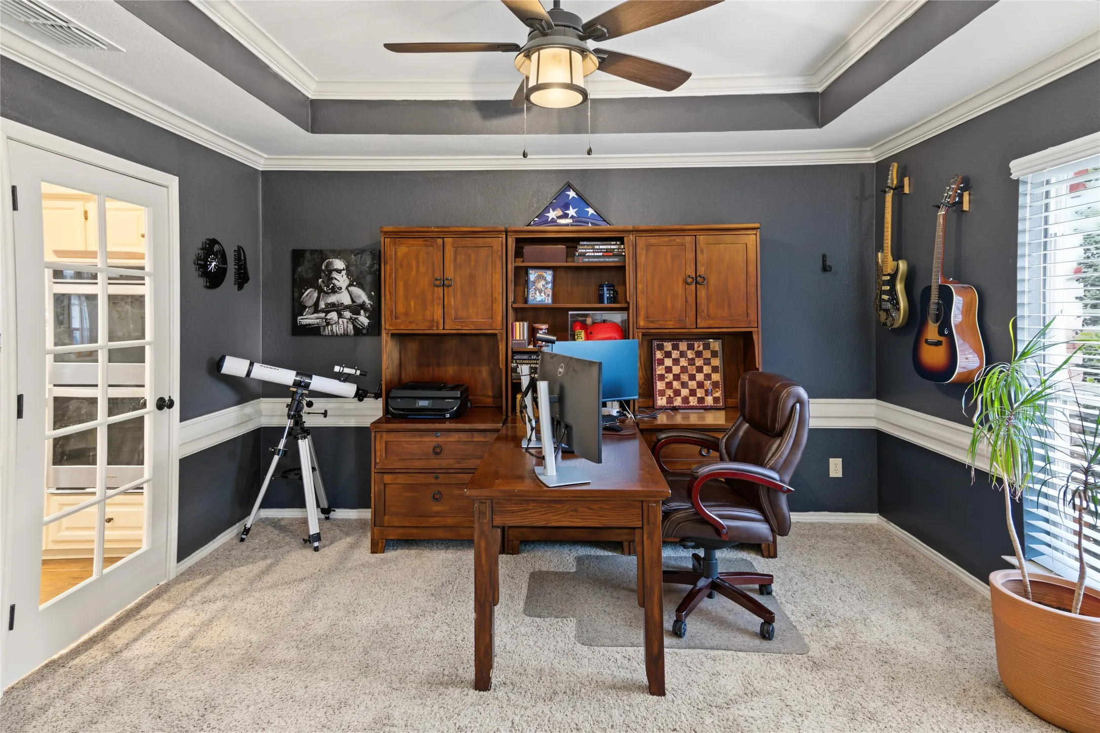 Tray ceiling with crown molding, ceiling fan, carpeted flooring, and French doors