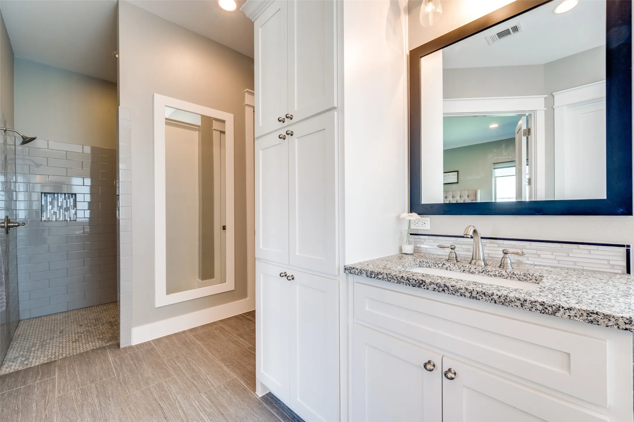 Walk-in shower with subway tile surround, built-in shower niche, and mosaic tile floor