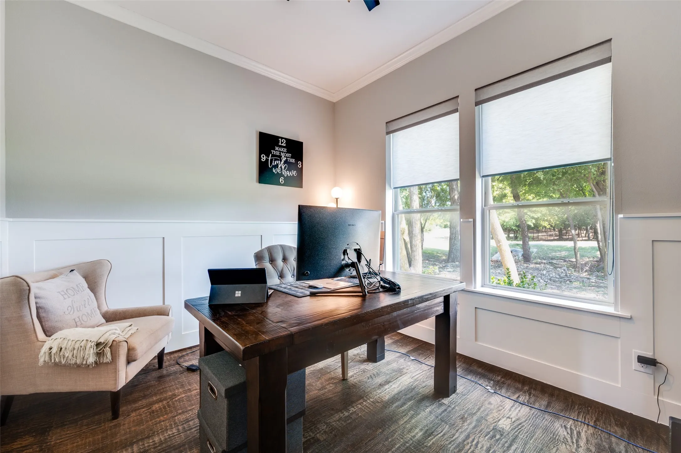 Wood-finish flooring, wainscoting, and crown molding detail the interior space