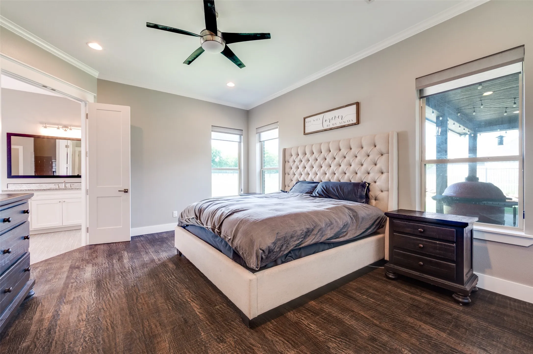 Wood-finish flooring, recessed lighting, ceiling fan, crown molding, and multiple windows with roller shades