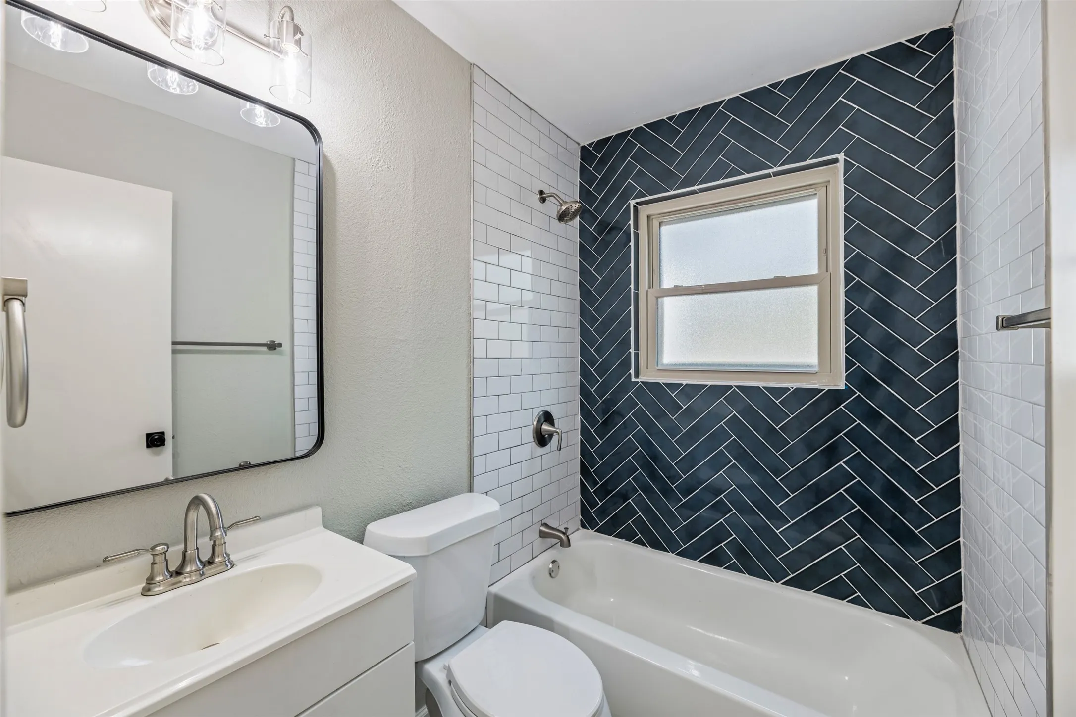 Bathroom with a new tub toilet, tile surround and faucet