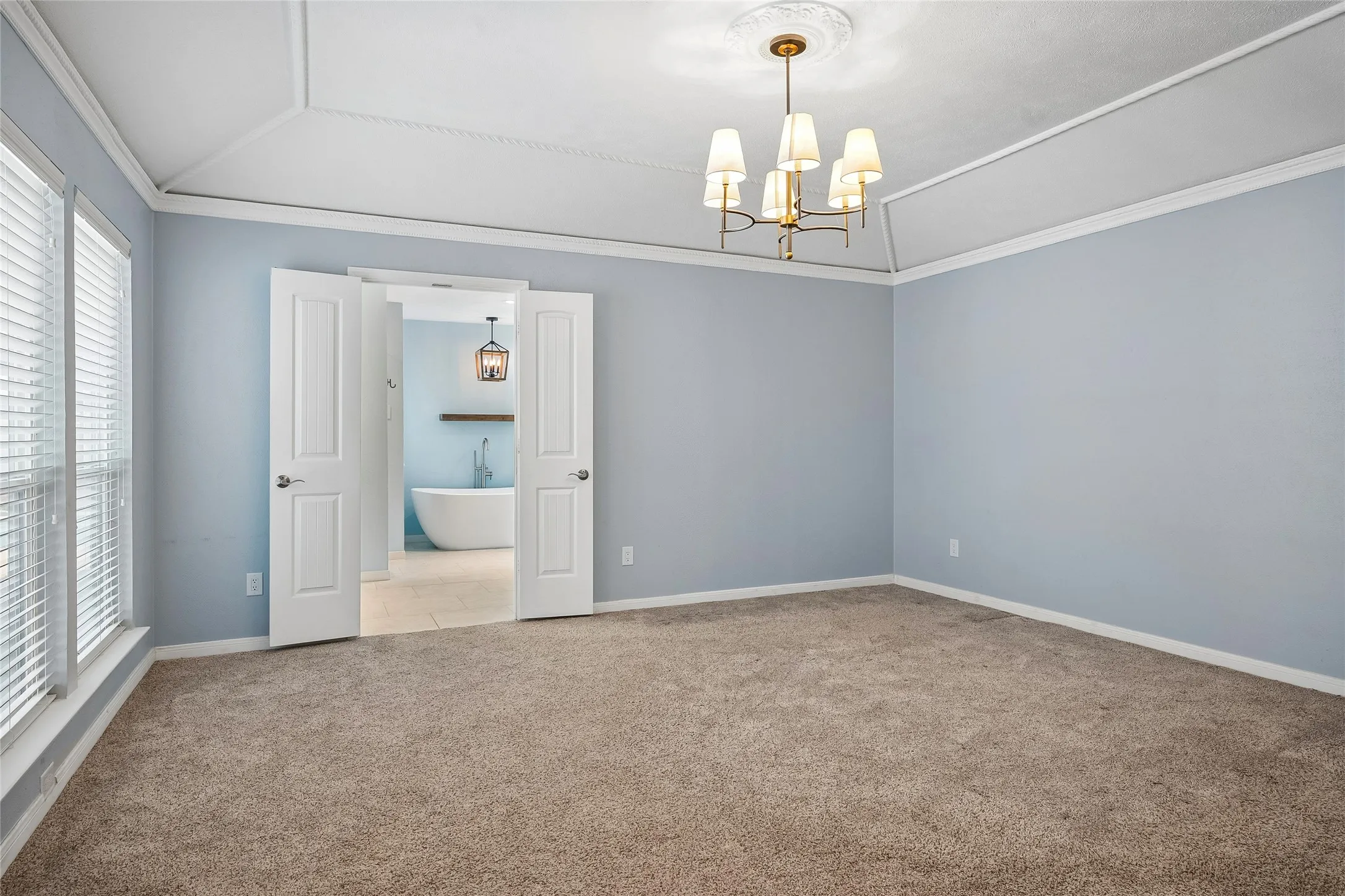 The spacious primary bedroom opens to a beautifully remodeled bath.