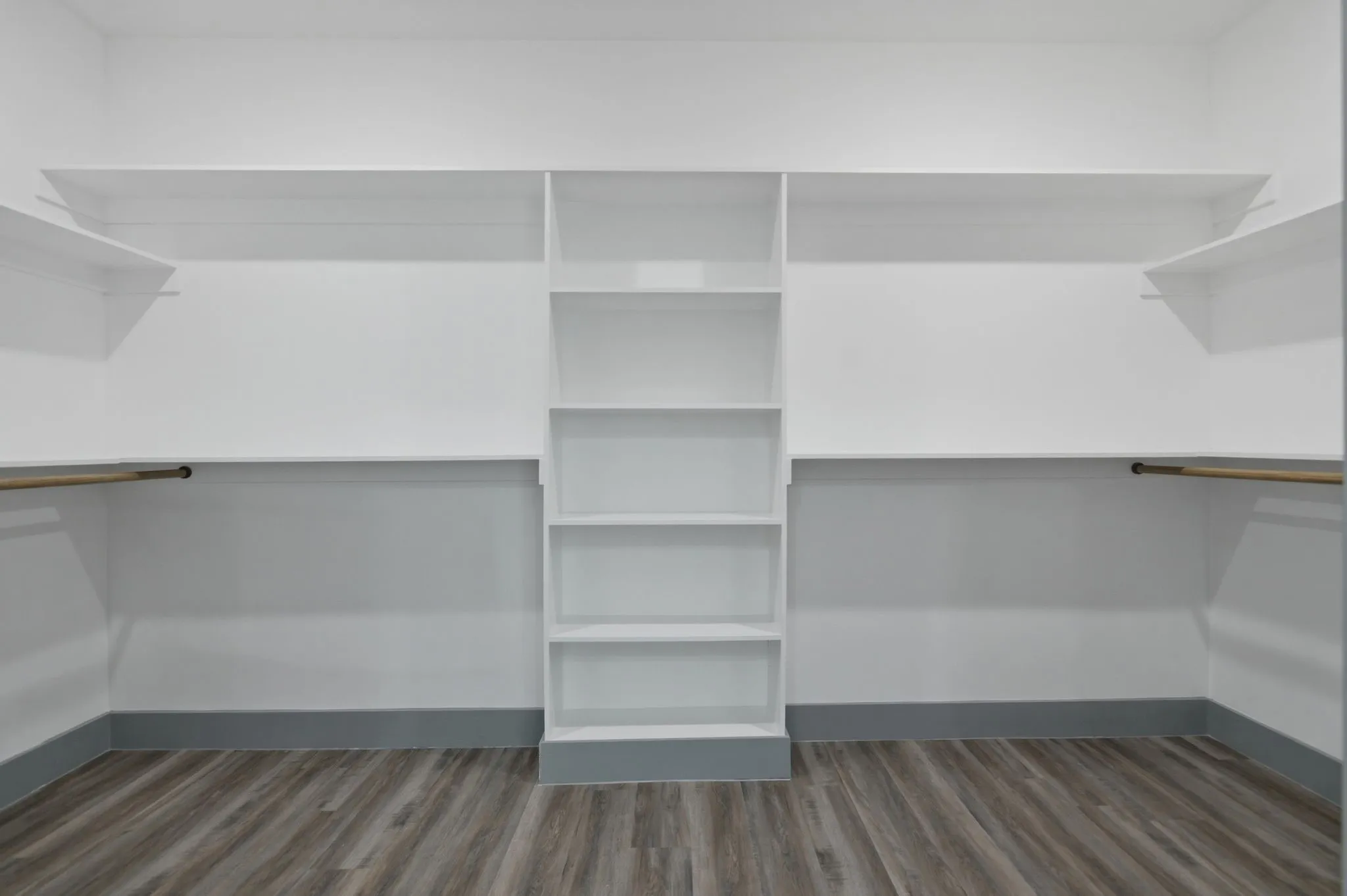 Built-in shelving, hanging rods, and wood-finish flooring