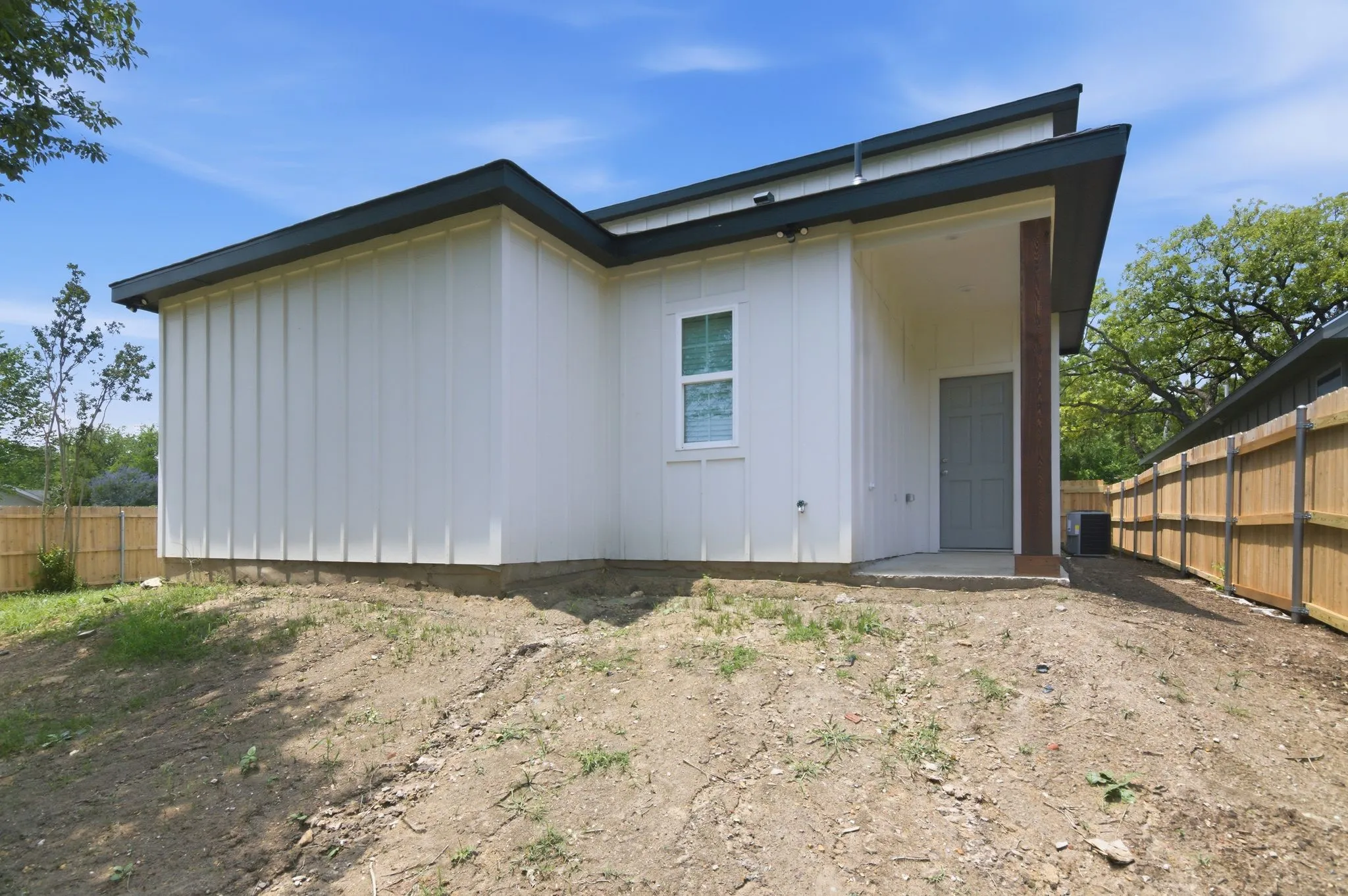 Modern exterior with board and batten siding, dark trim, and a covered entry