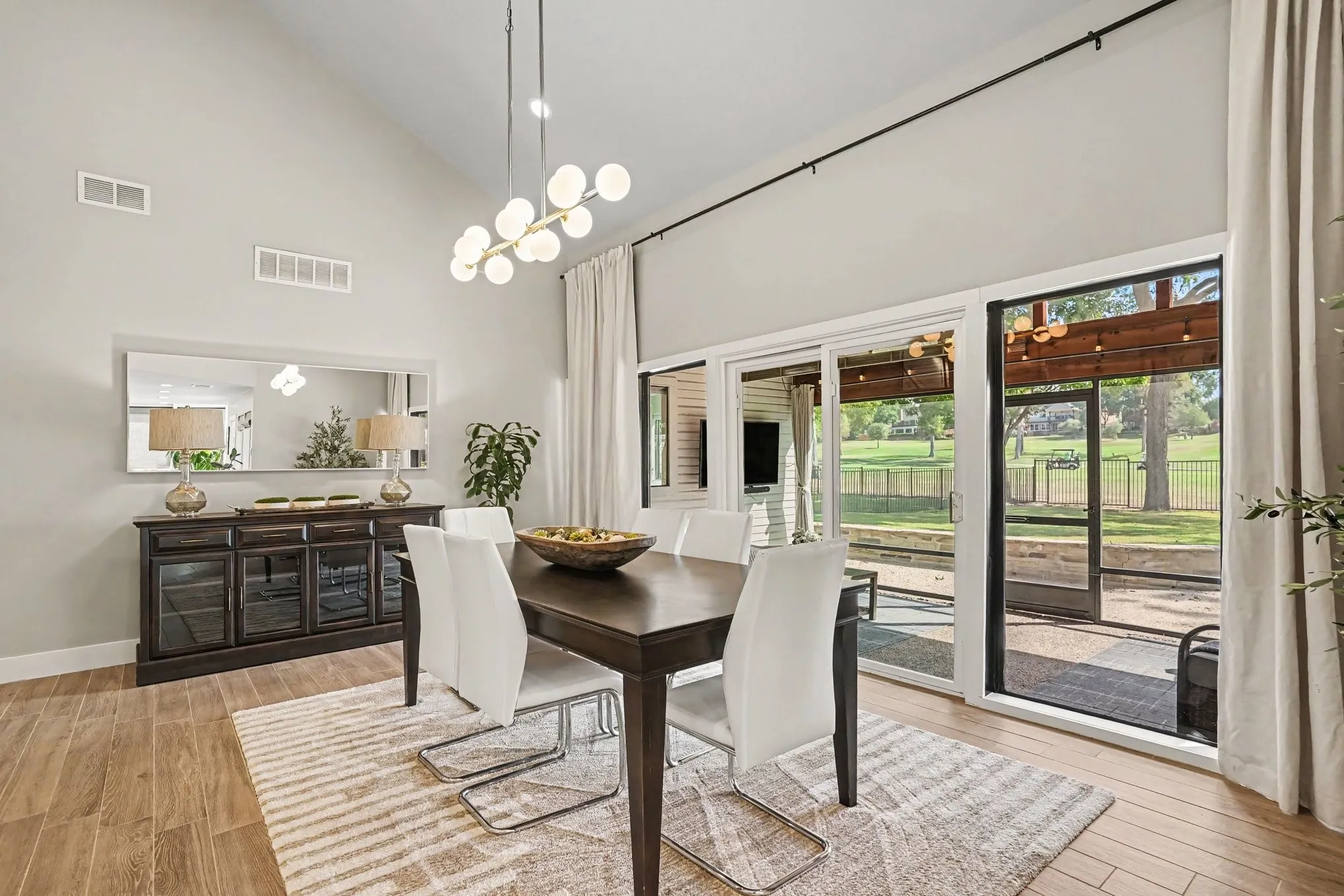 Dining room with decorative lighting looks out to golf course