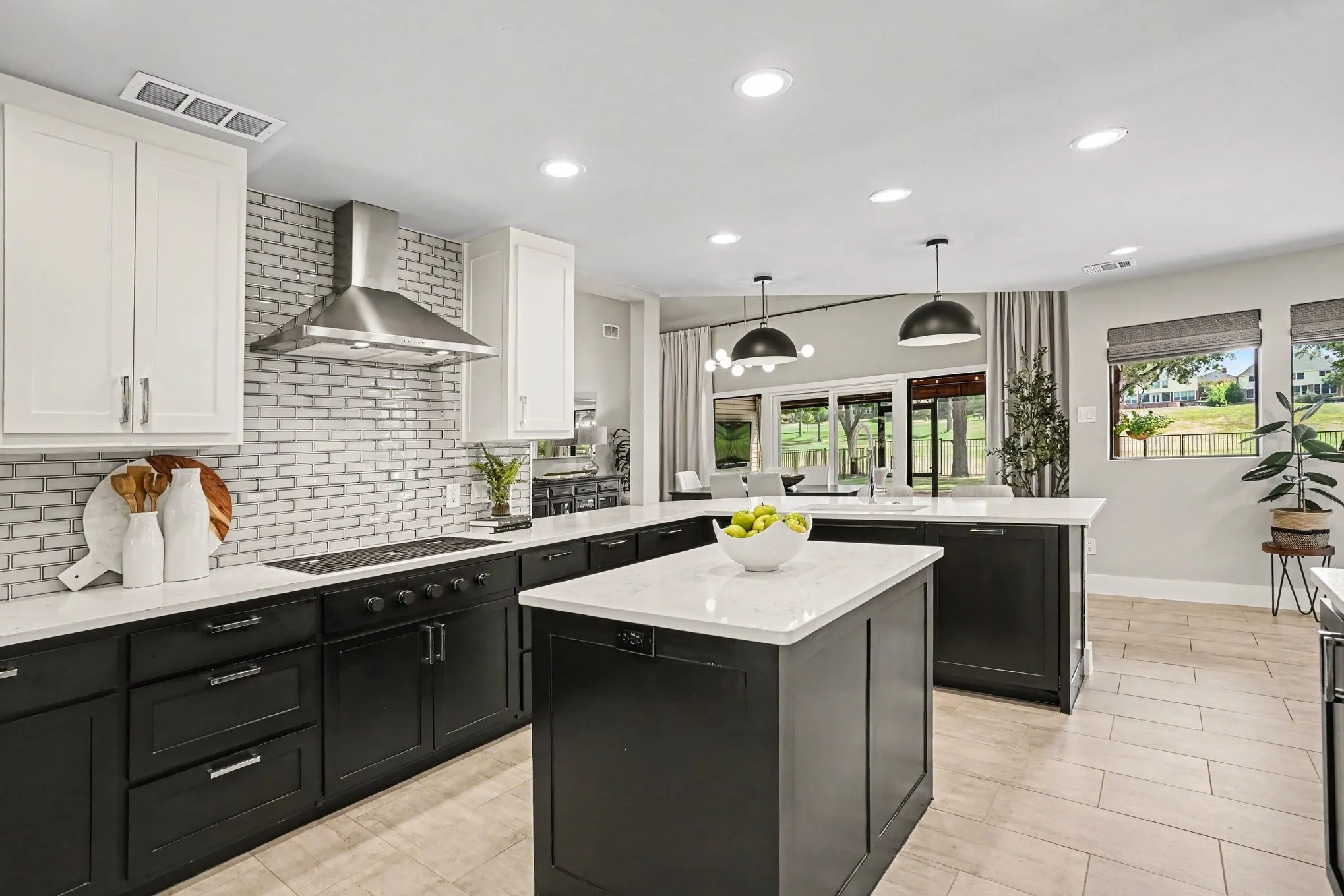 Kitchen with decorative tile backsplash, gas cooktop, vented hood