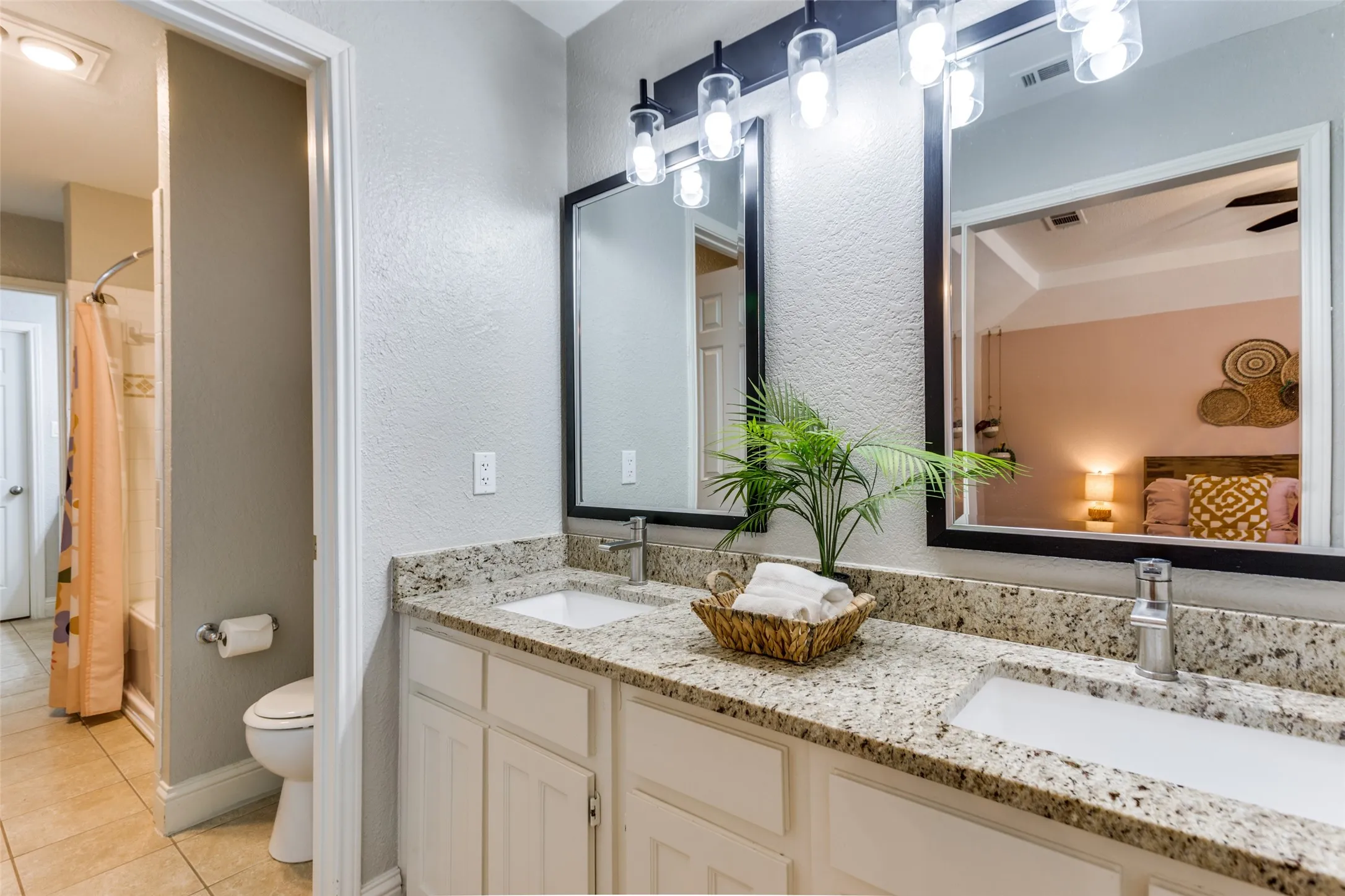 Double vanity with a granite countertop, undermount sinks, and brushed nickel faucets