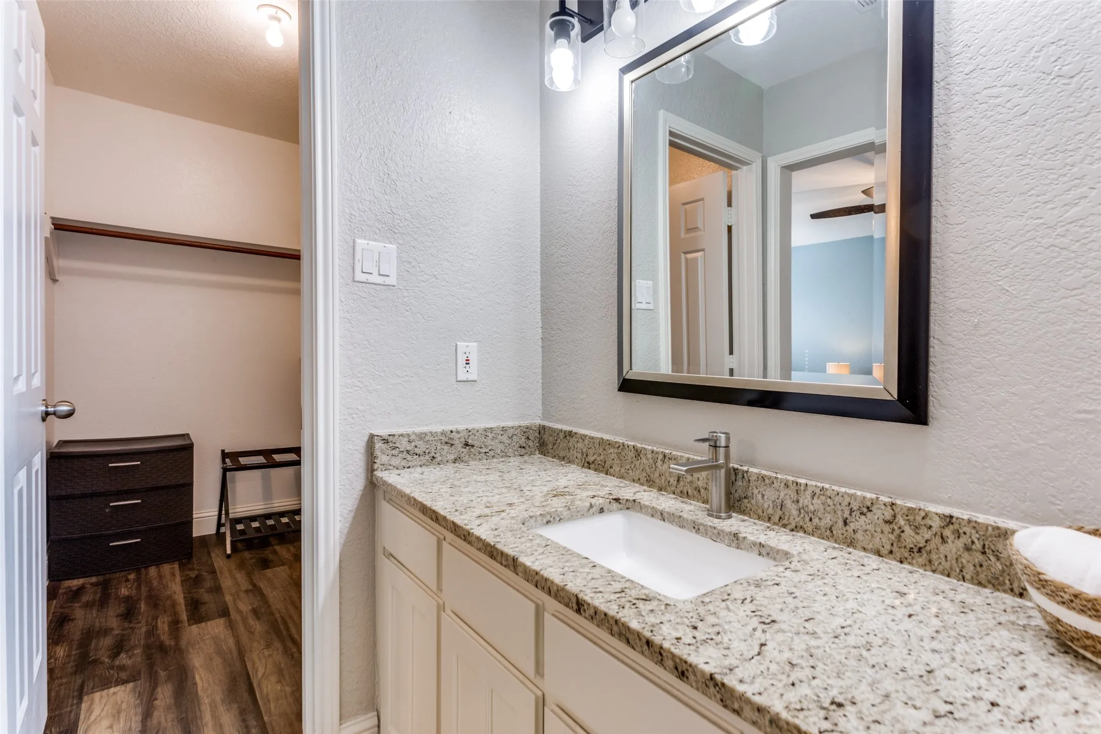 Vanity with a granite countertop, undermount sink, and brushed nickel faucet