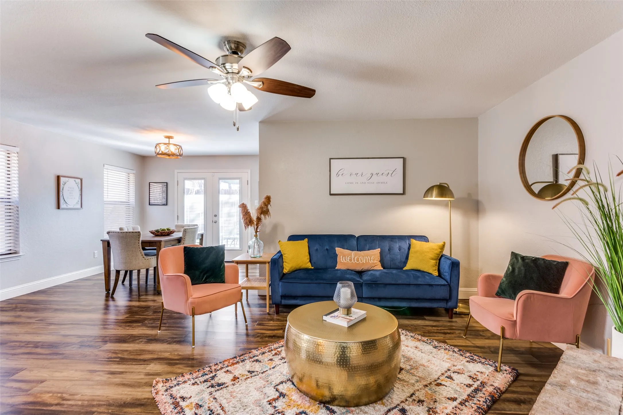 Wood-finish flooring throughout, ceiling fan with light fixture, and ample natural light from multiple windows