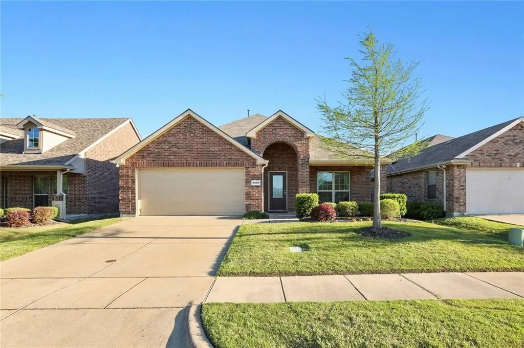 Brick exterior, attached two-car garage, concrete driveway, front yard landscaping, and a covered entry