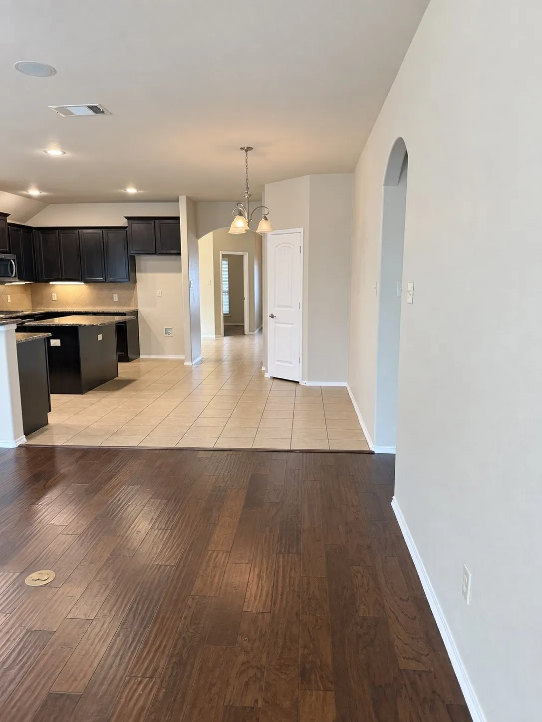Wood-finish flooring, recessed lighting, and an arched entry
