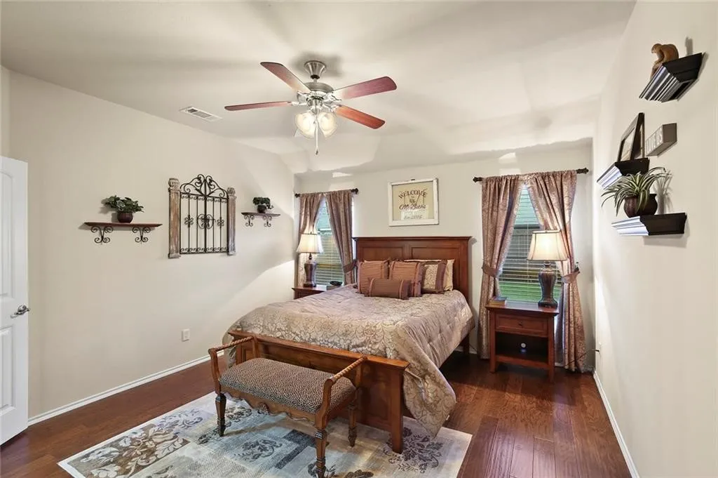 Wood-finish flooring, ceiling fan, and painted walls