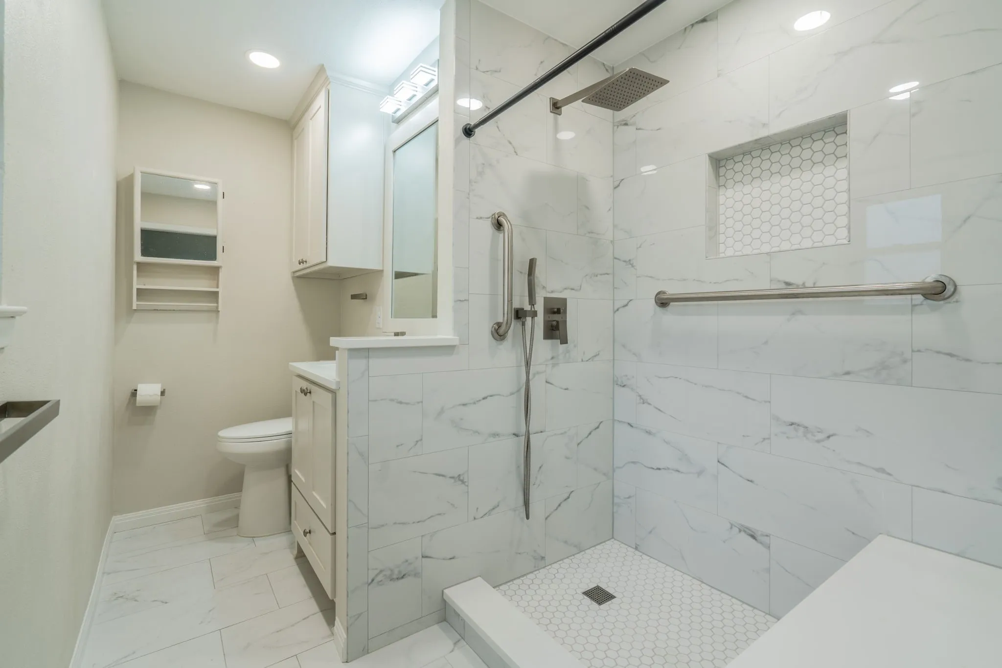 Shower with white marble-style wall tiles and a built-in bench