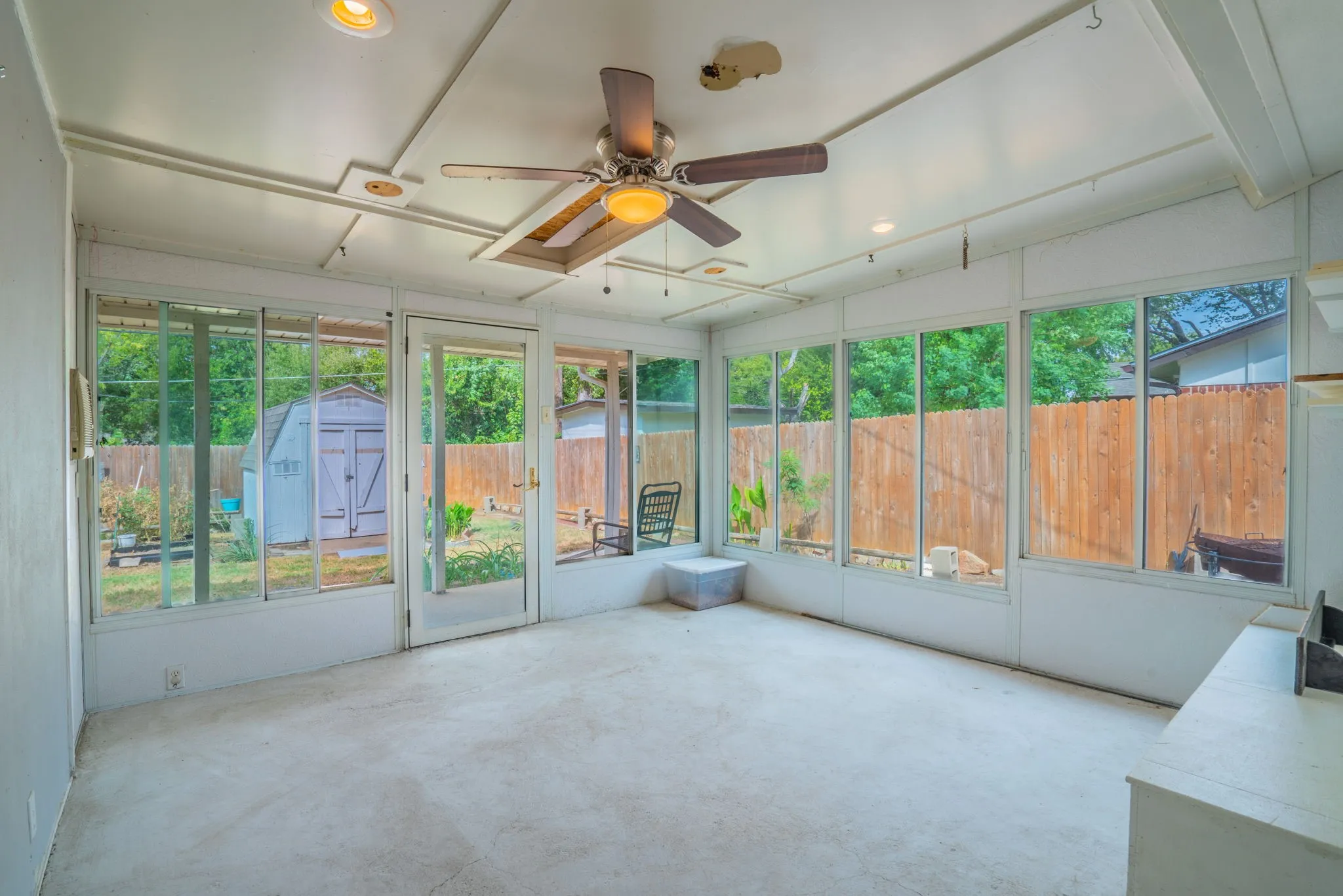 Enclosed sunroom with expansive windows, a ceiling fan, recessed lighting, and a rear yard access door