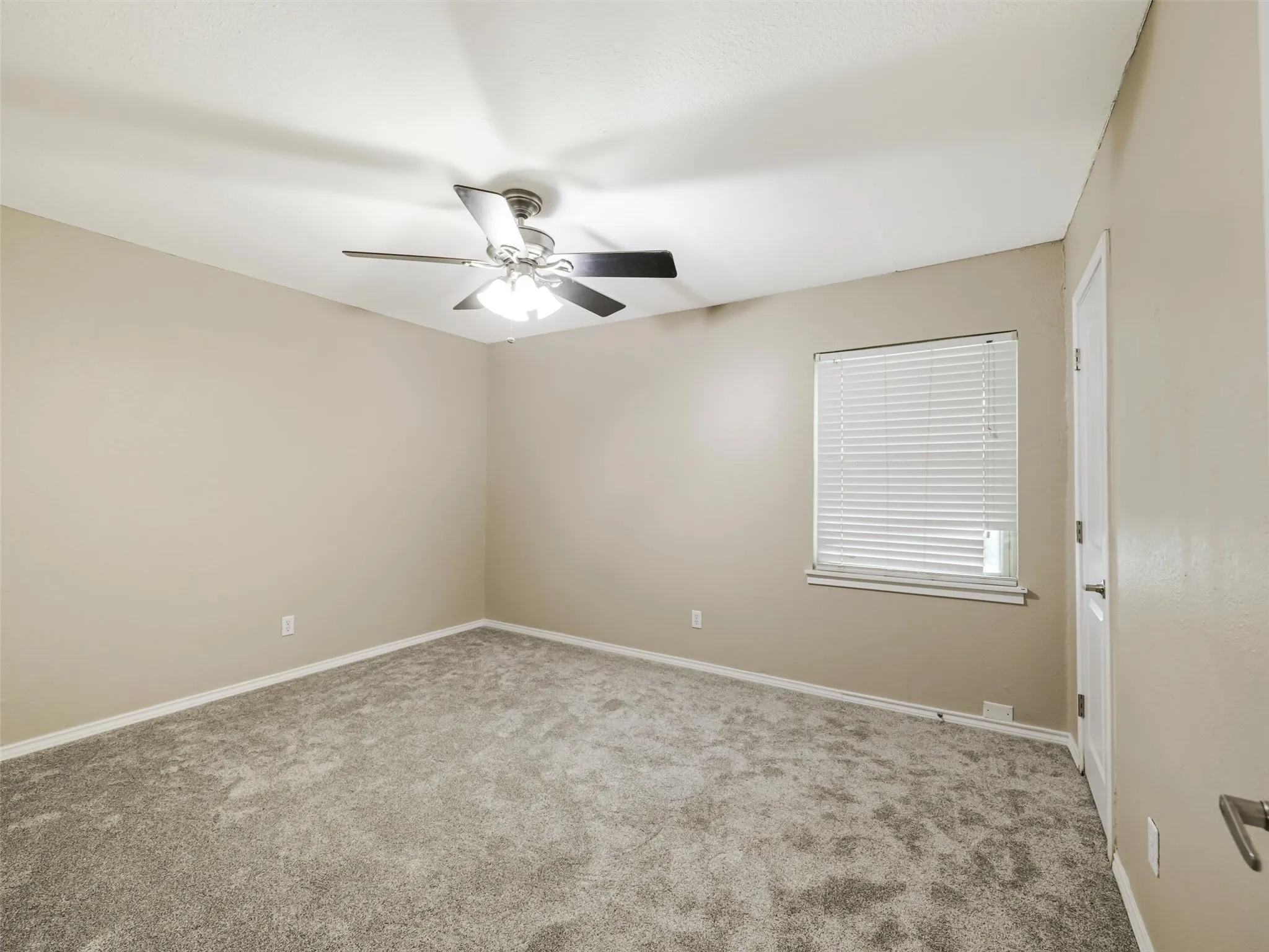 Recessed window with horizontal blinds, ceiling fan with integrated lighting, and neutral wall color