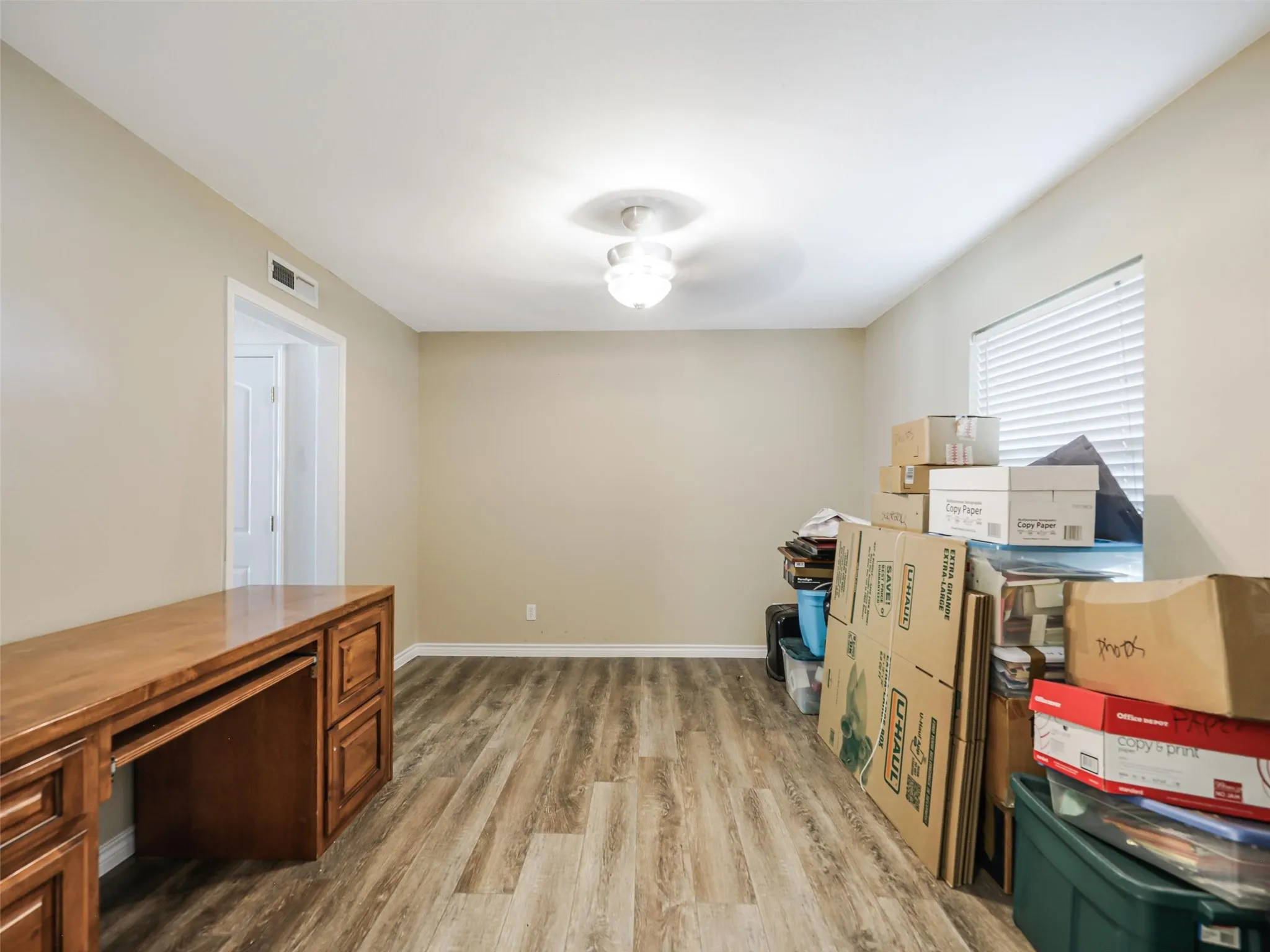 Wood-finish flooring, neutral wall tones, recessed lighting, and a built-in wood desk