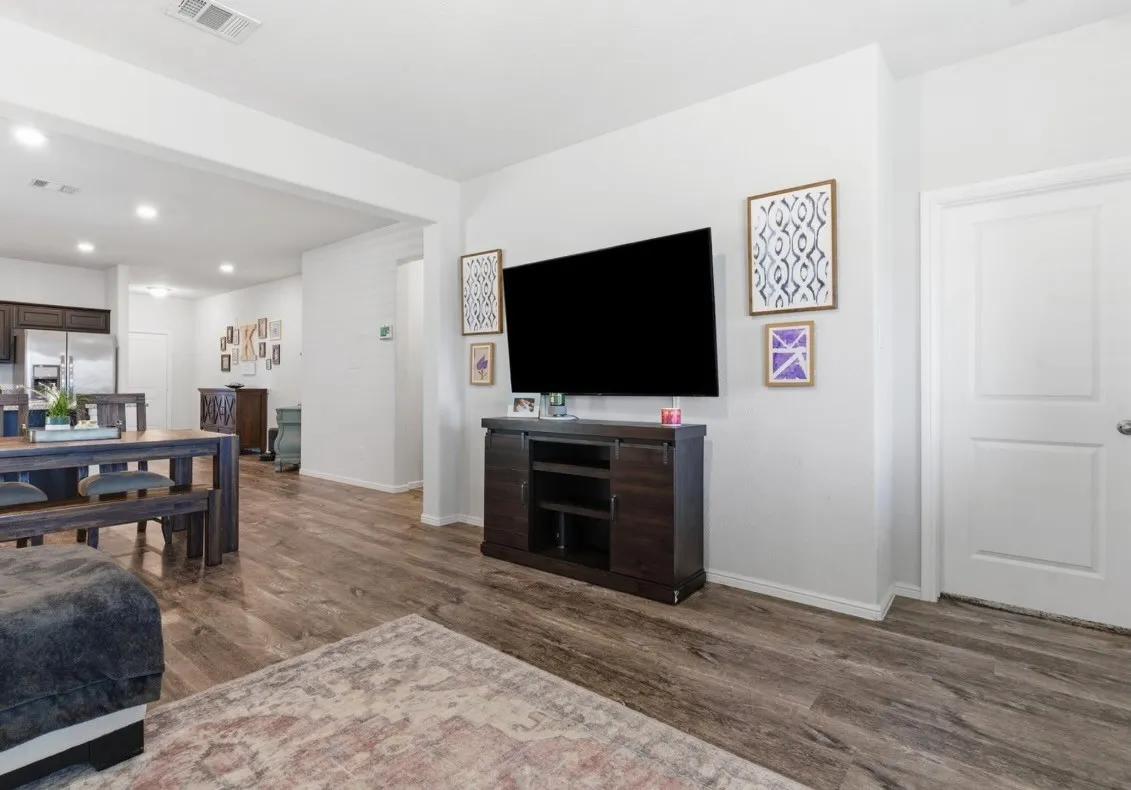 Wood-finish flooring throughout, bright white walls, and recessed lighting