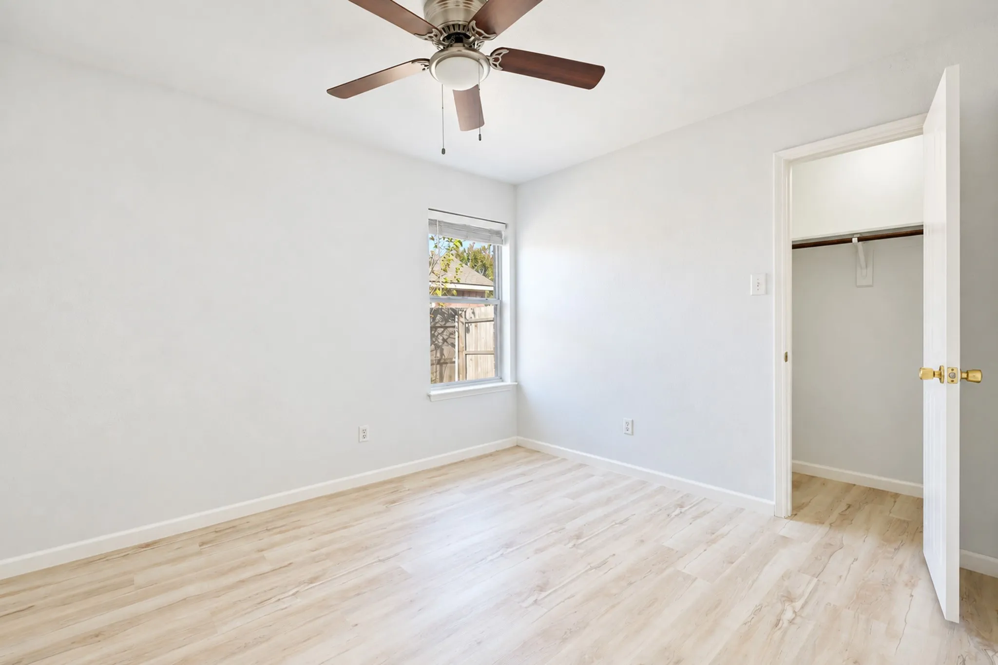 Recessed window, wood-finish flooring, ceiling fan, and a built-in closet with hanging rod