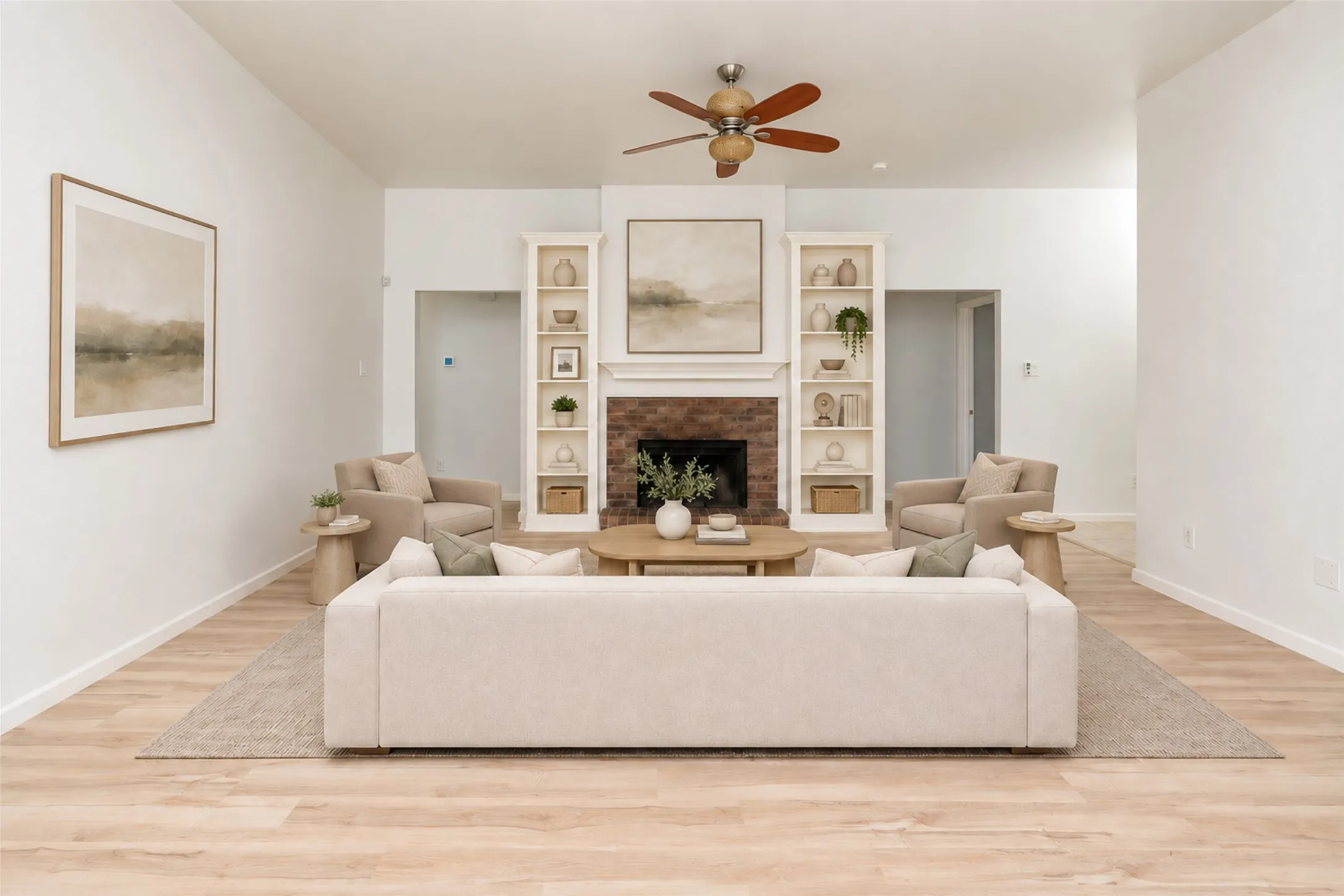 Vaulted ceiling with a ceiling fan, light wood-finish flooring, brick fireplace with a mantel, and built-in shelving