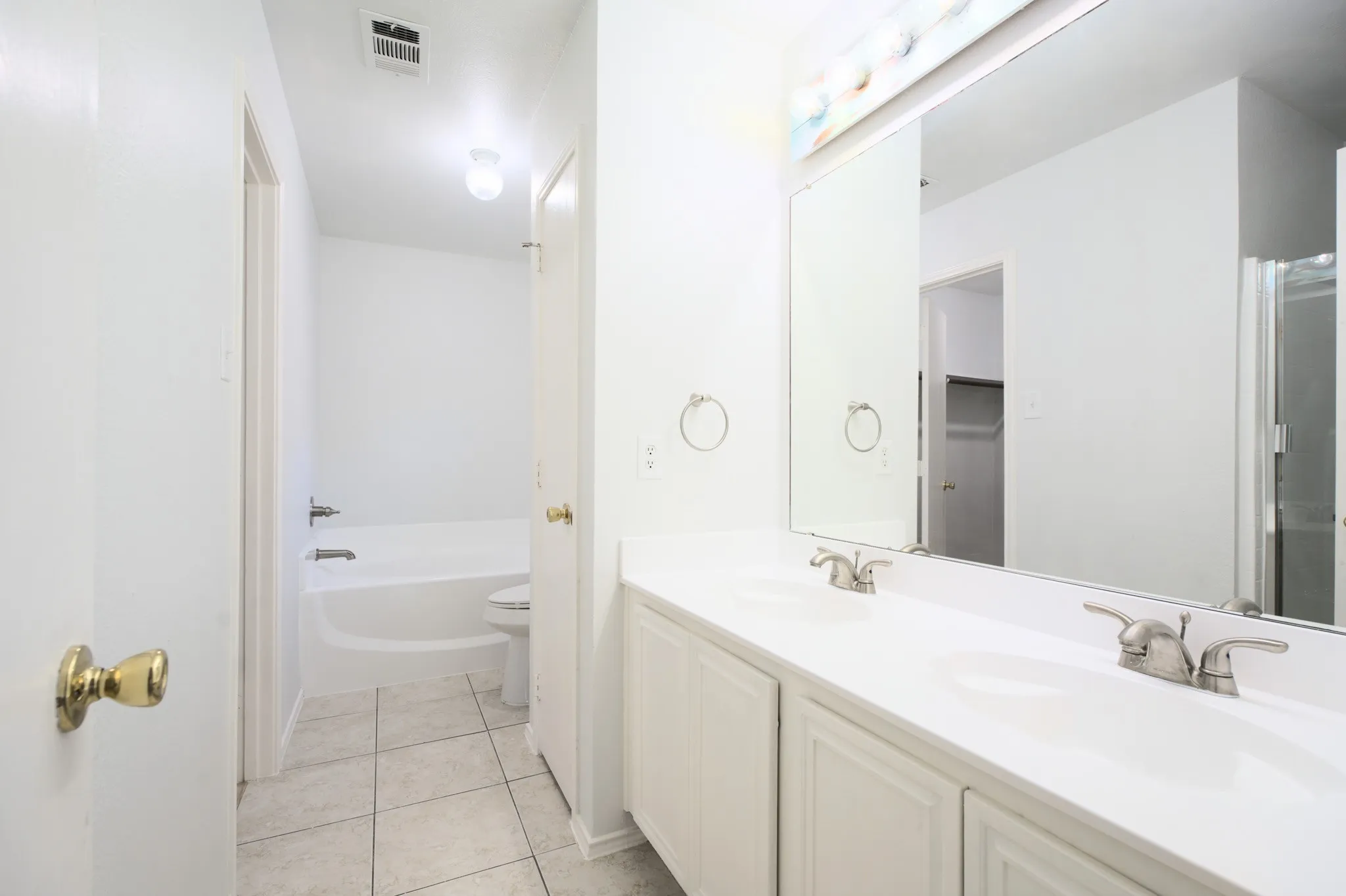 Double vanity with integrated sinks, white cabinetry, and brushed nickel fixtures
