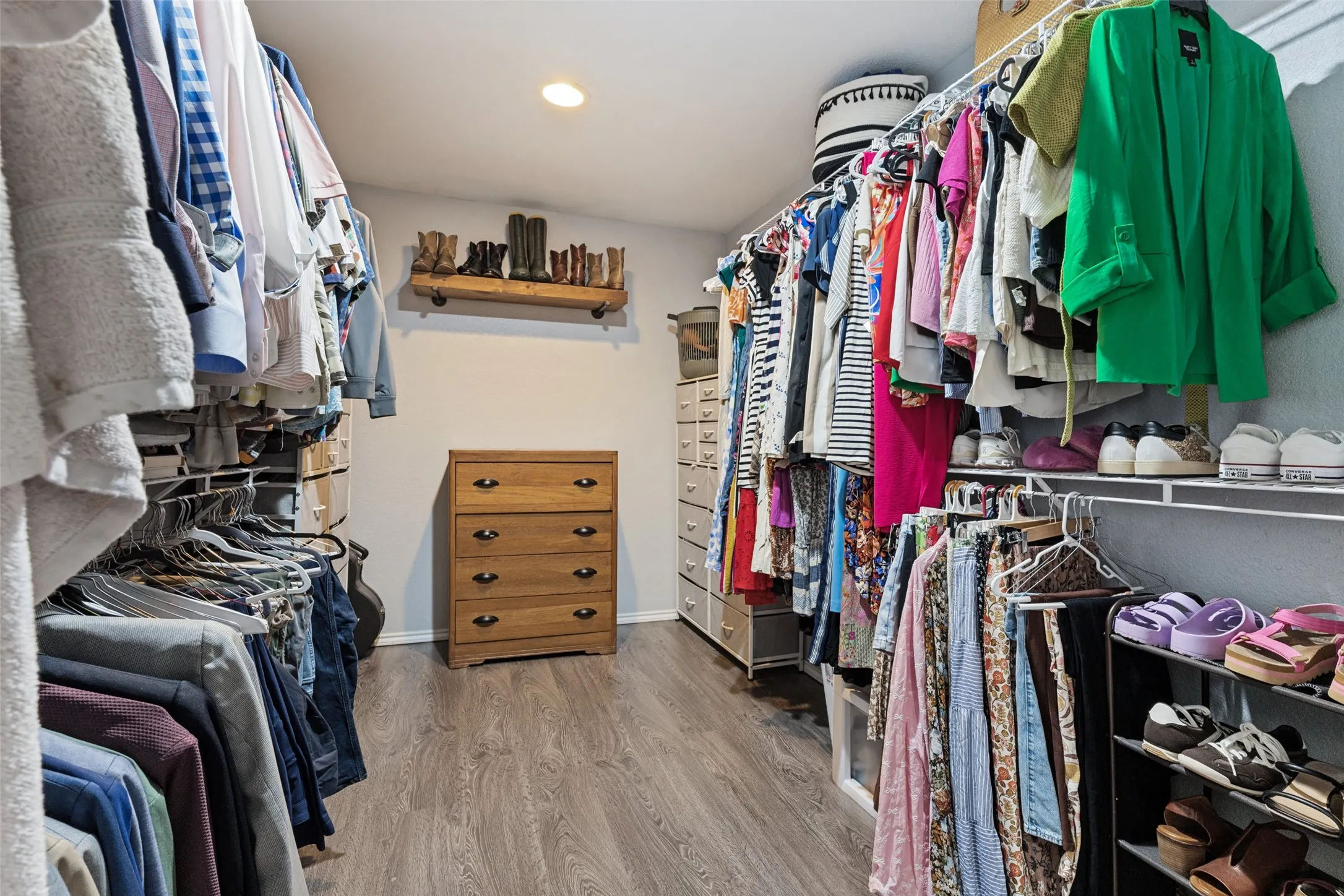Walk-in closet featuring wood-finish flooring, recessed lighting, and built-in shelving