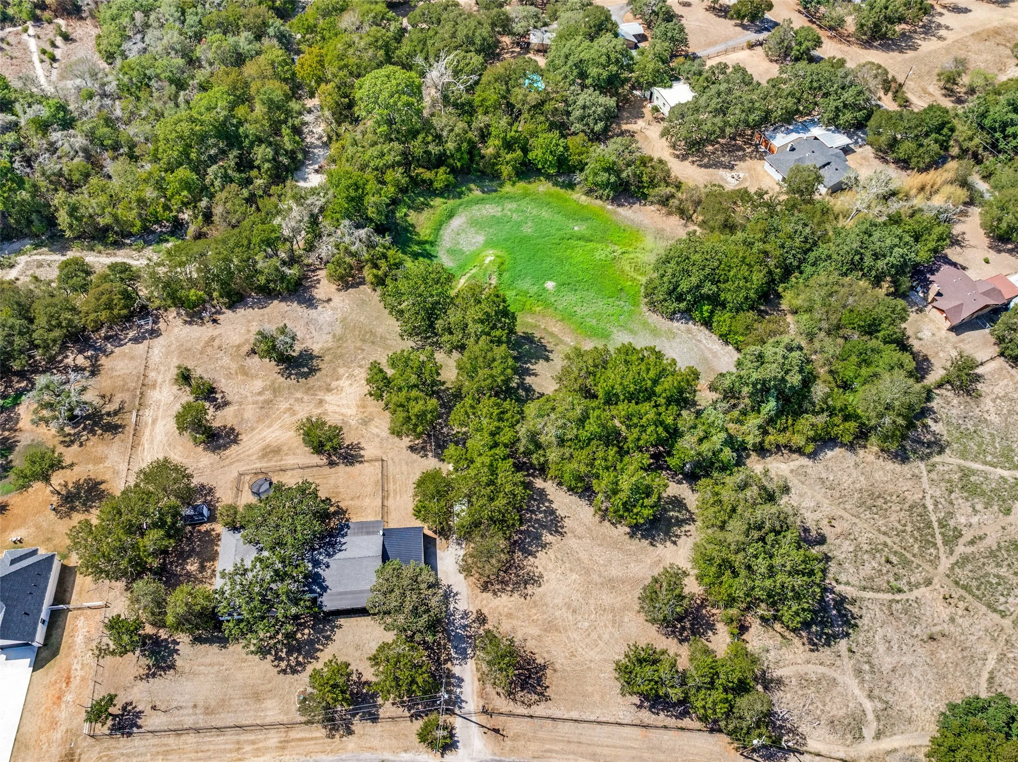 Expansive property featuring a treed landscape, natural terrain, and visible fencing