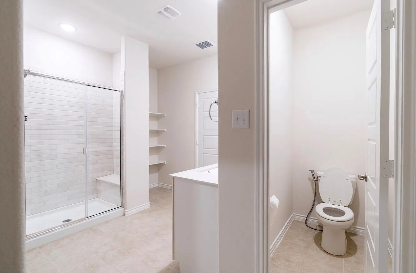 Tiled shower with glass enclosure and built-in bench